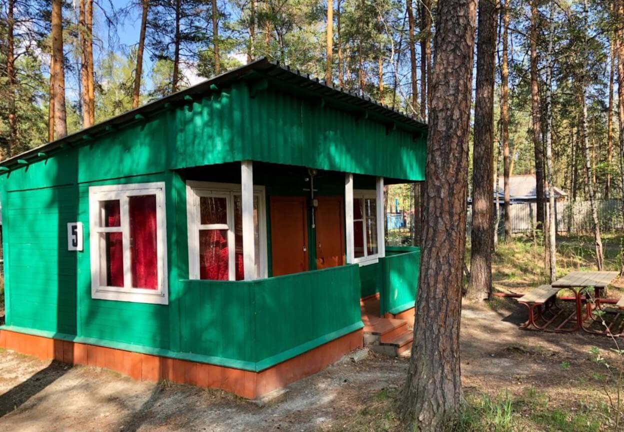 Маленький деревянный домик для отдыха. Выкрашен в природный зеленый цвет.