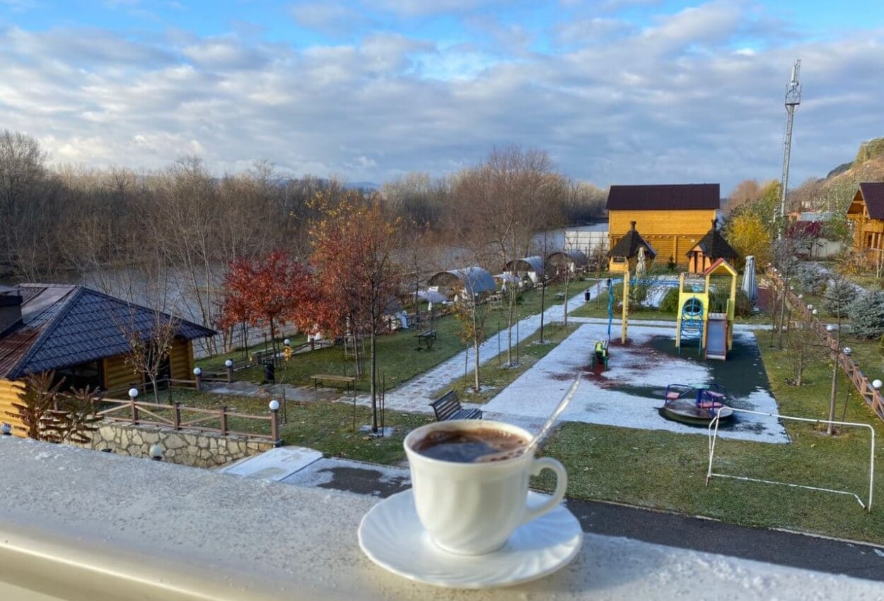 Чашка кофе с видом на территорию комплекса и детскую площадку.