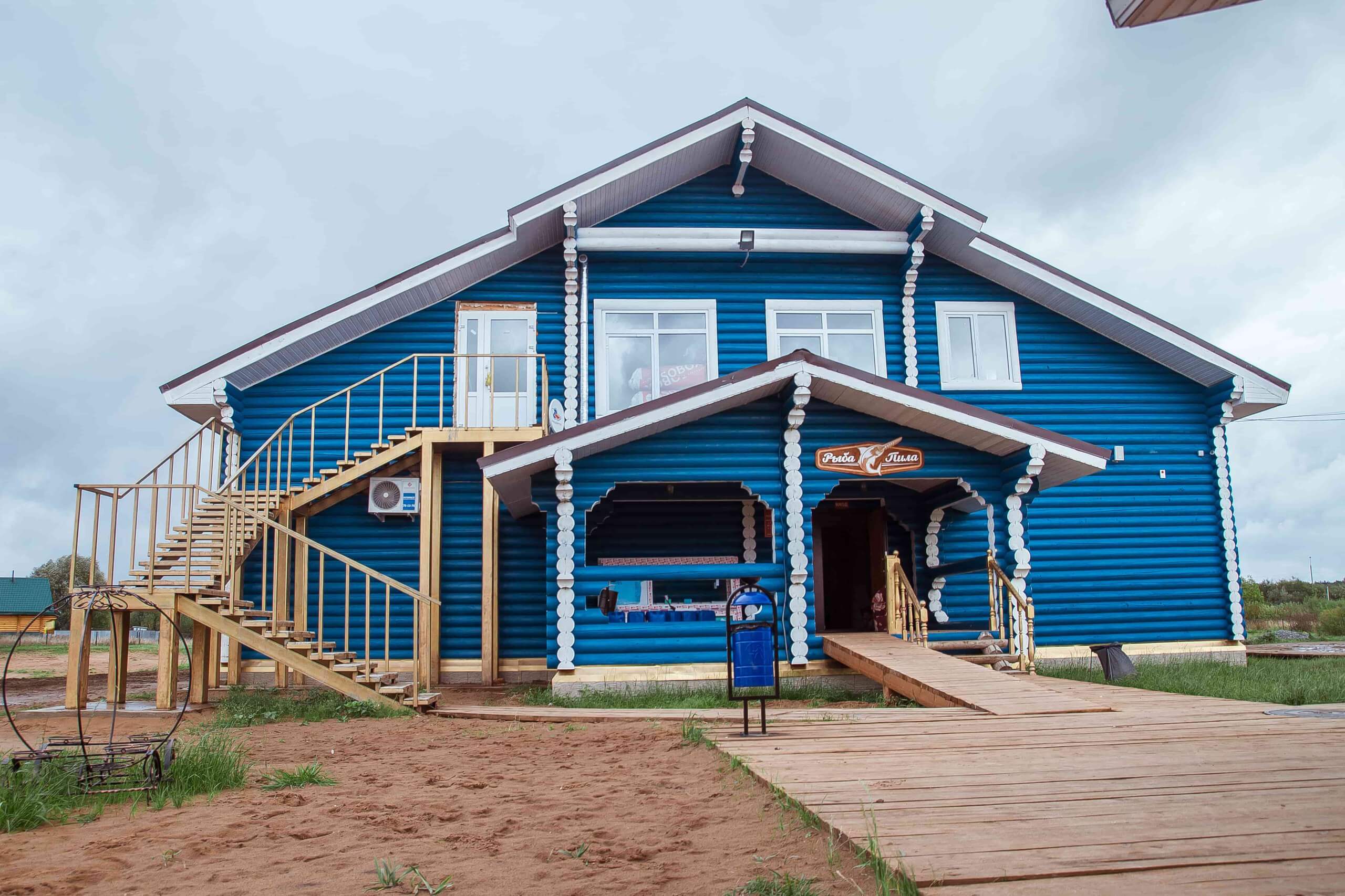 Один из корпусов: синий дом из оцилиндрованного бревна.
