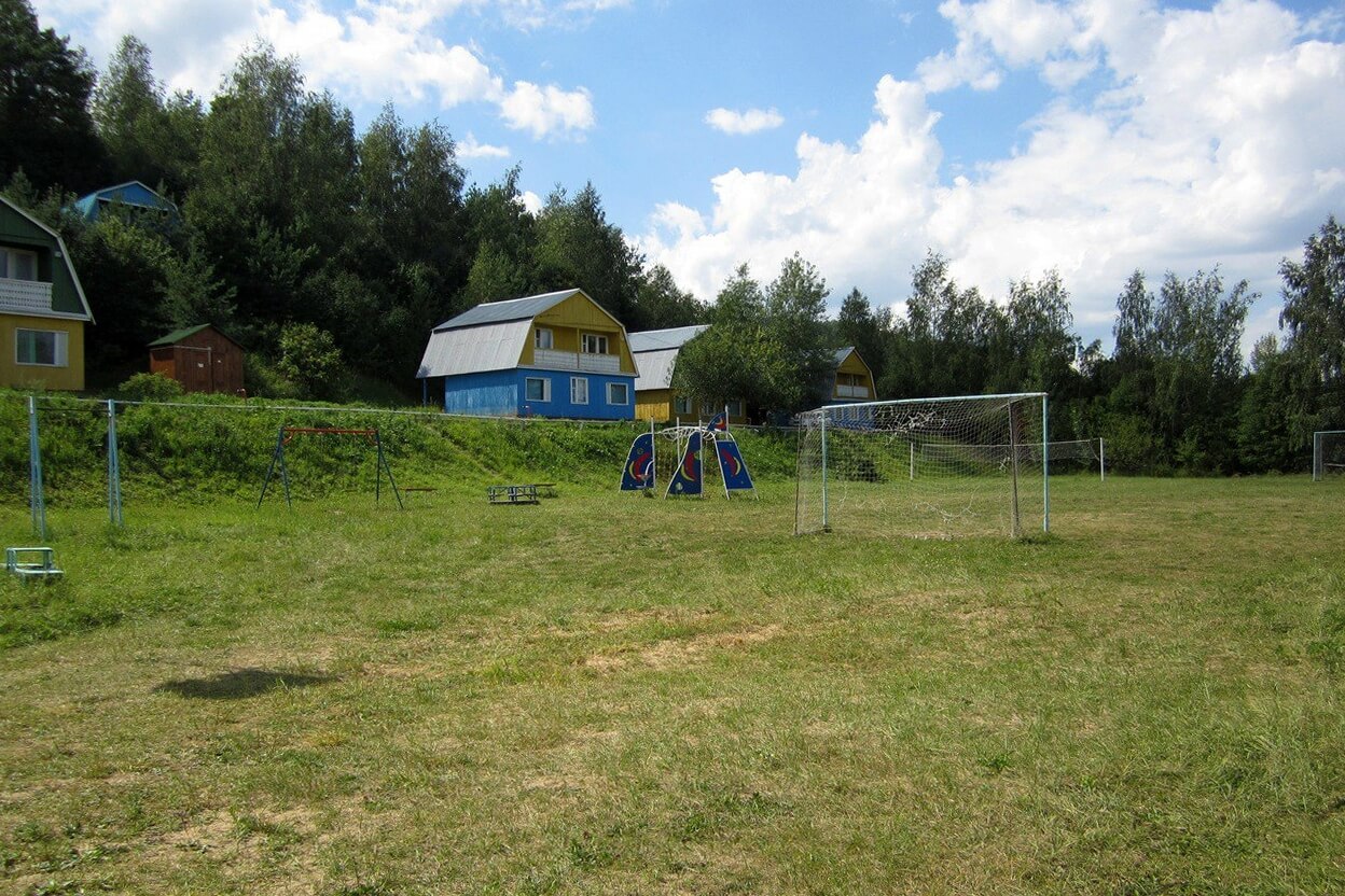 Футбольное поле, остатки детской площадки и корпуса базы отдыха.