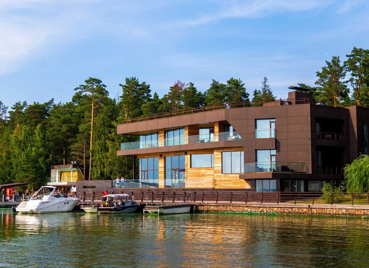 Роскошный отель, на берегу пришвартованы лодки и небольшие катера.