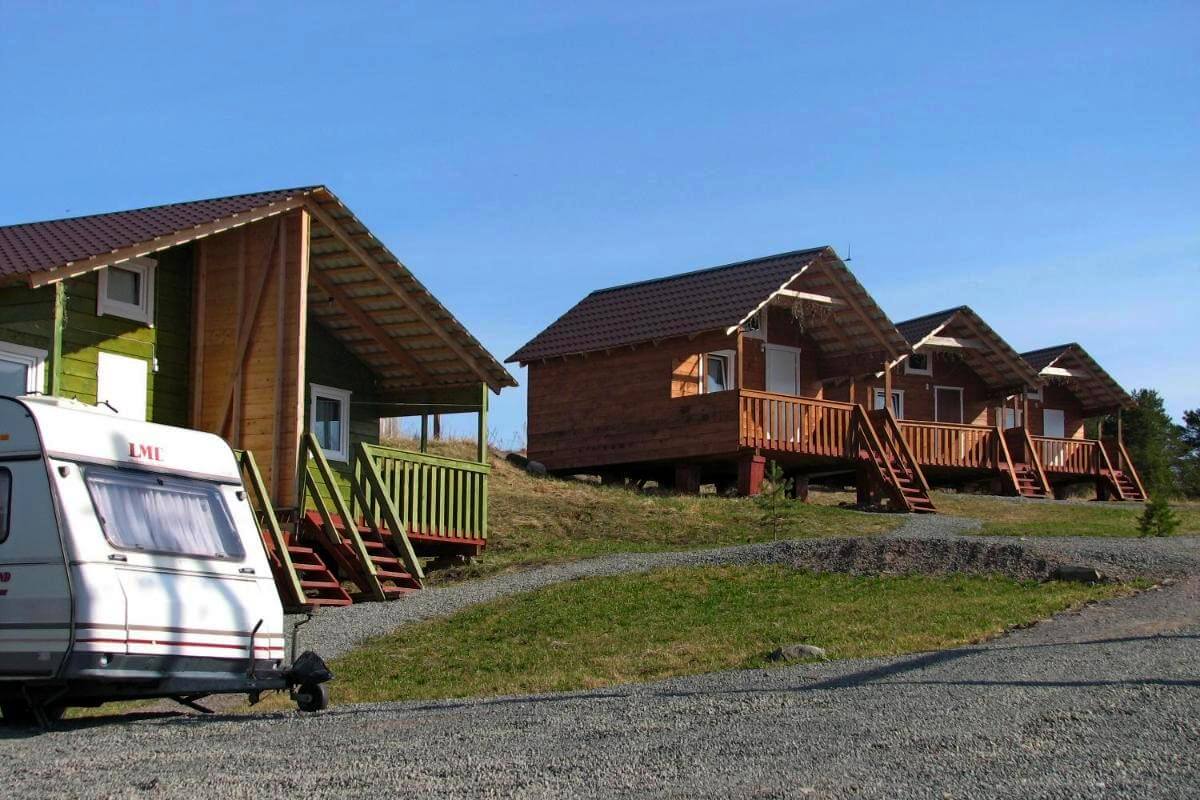 Трейлер-прицеп и небольшие, деревянные дома для отдыха.