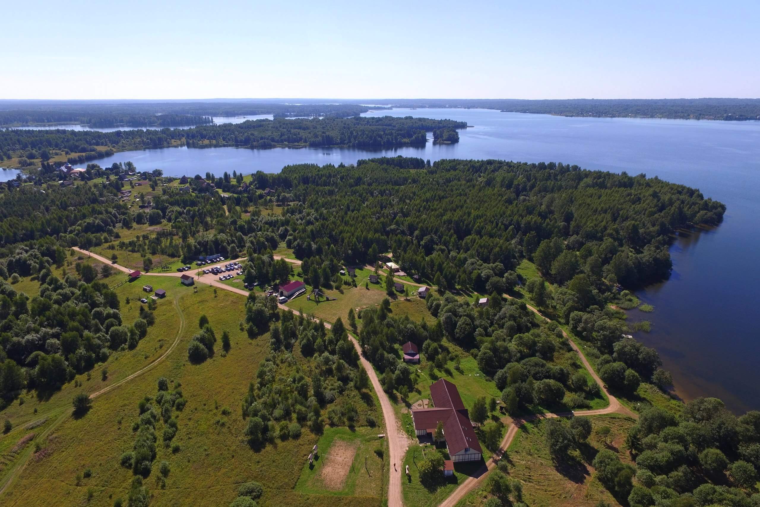 Панорамный вид на территорию базы отдыха. Лес и озеро.