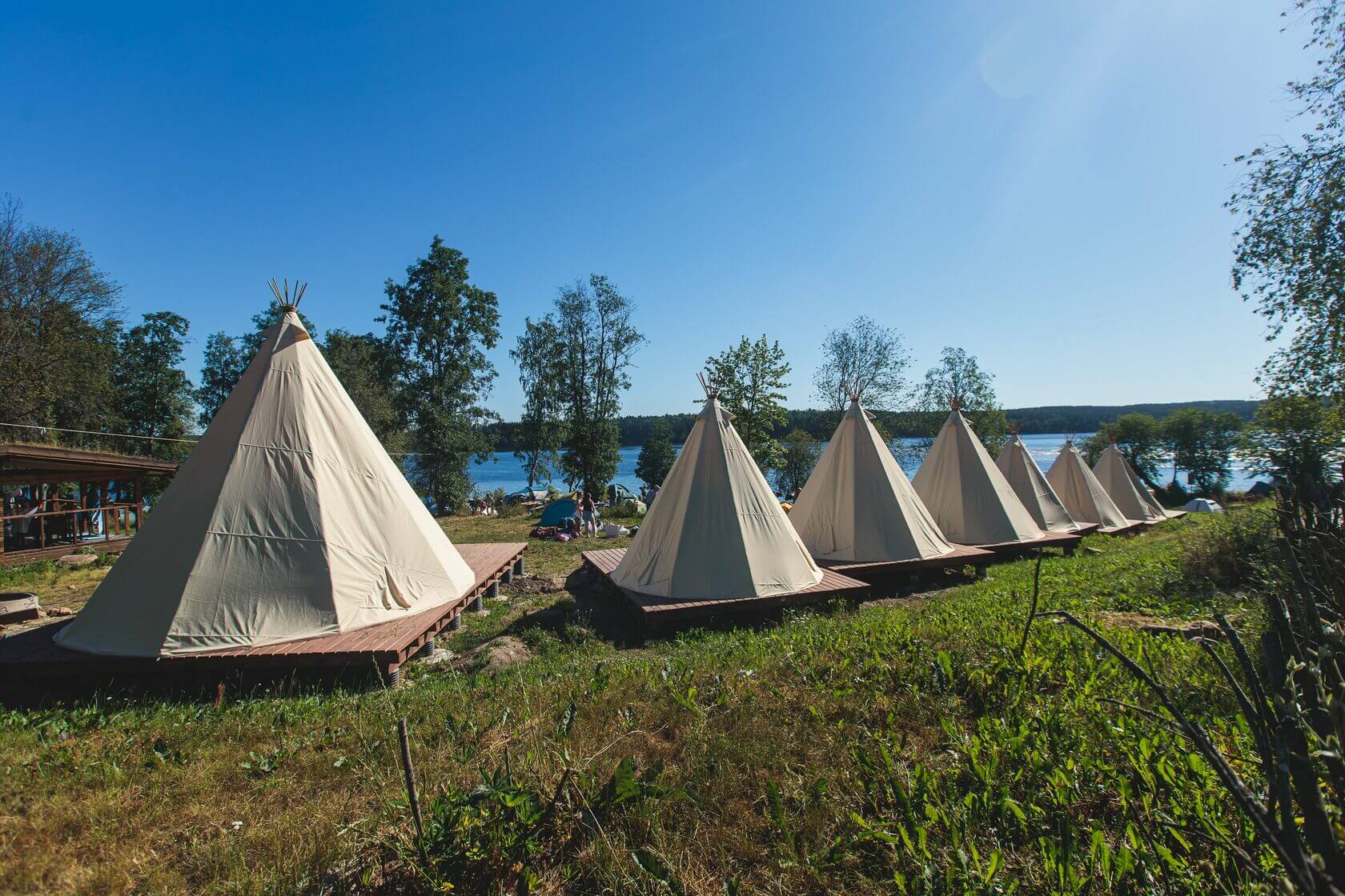Палатки-типи на деревянных подиумах с видом на озеро.