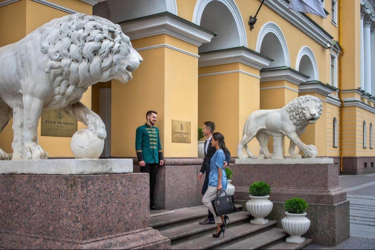 Статуи львов и швейцар у входа.