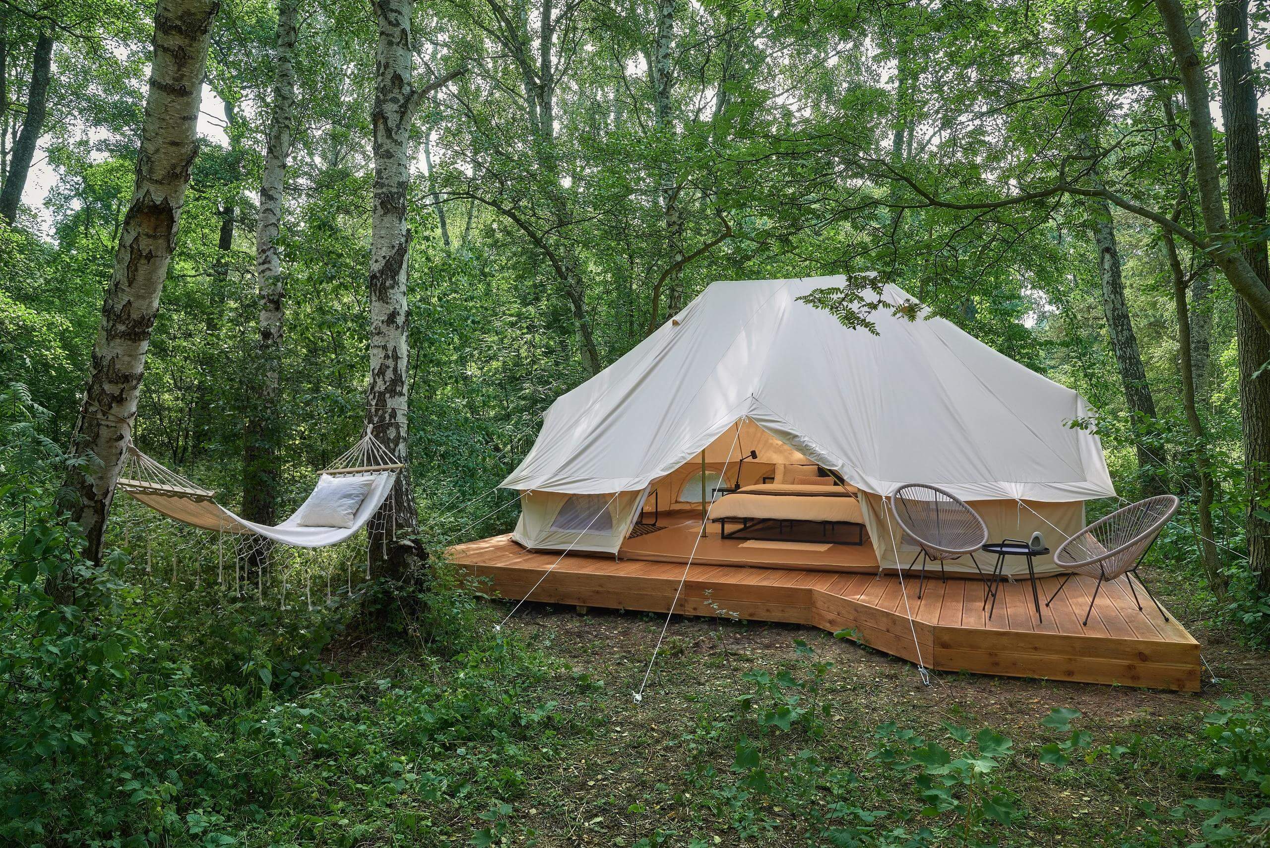 Шатер-палатка установлен на деревянном подиуме, рядом гамак для отдыха.