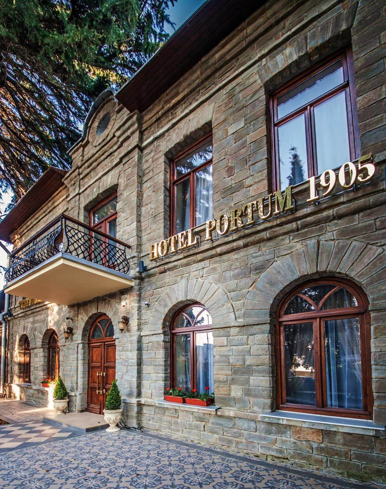 Яркая золотая вывеска с названием отеля: "HOTEL PORTUM 1905".