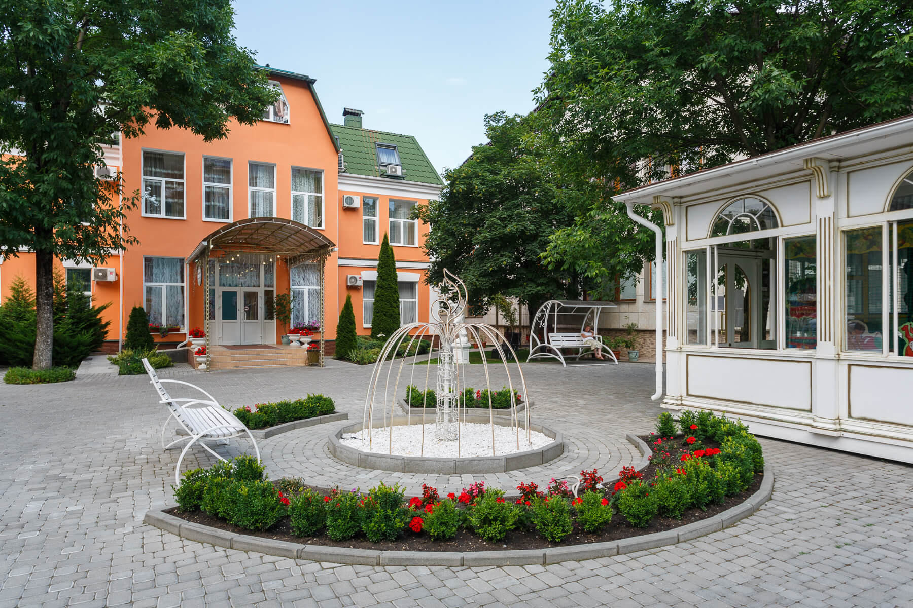 Территория перед отелем украшена скульптурами и клумбами с цветами.