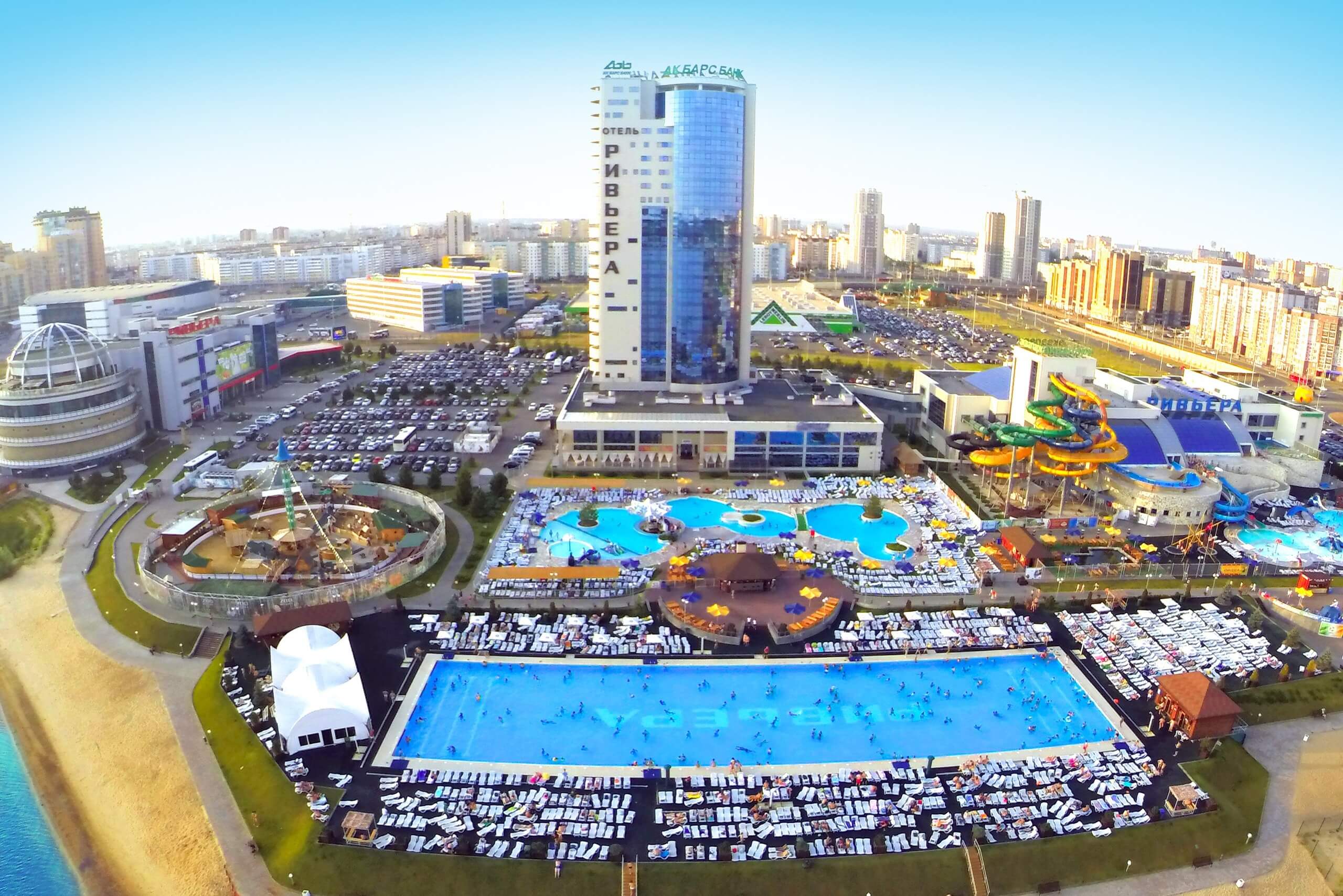 Панорамный вид: аквапарк, здание отеля и парковка.