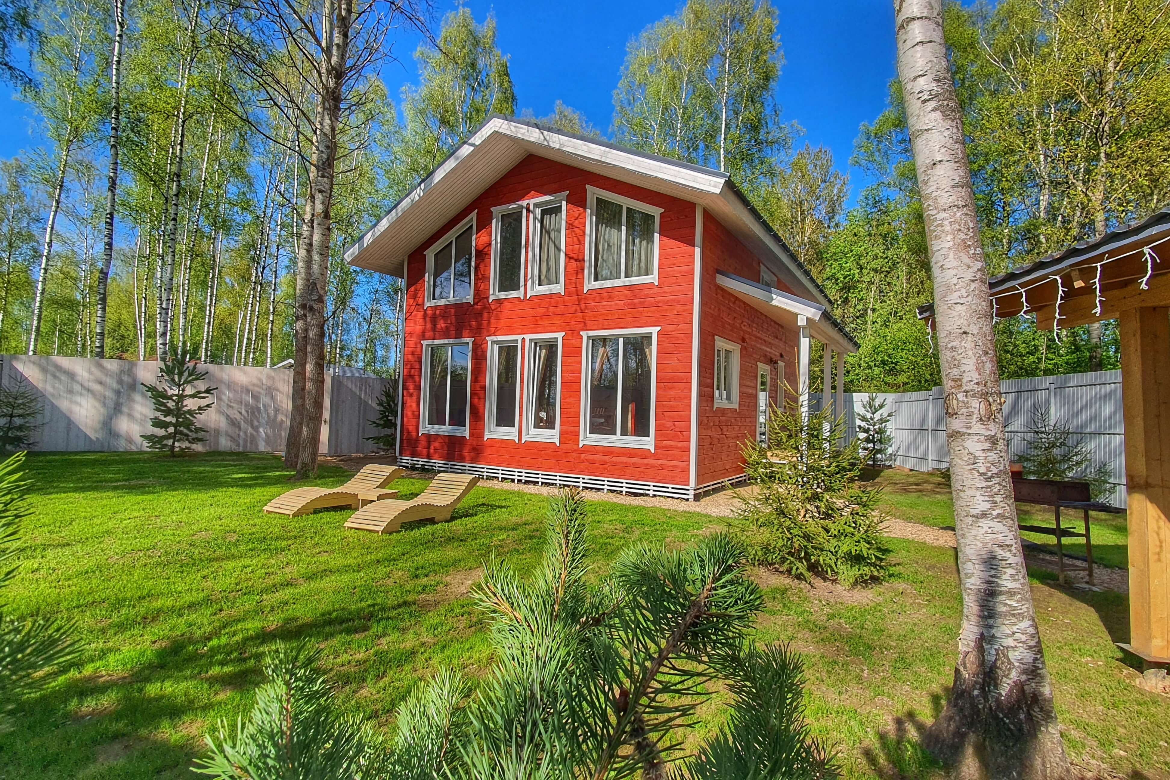 На газонах установлены деревянные шезлонги, а дома выкрашены в яркий, красный цвет.