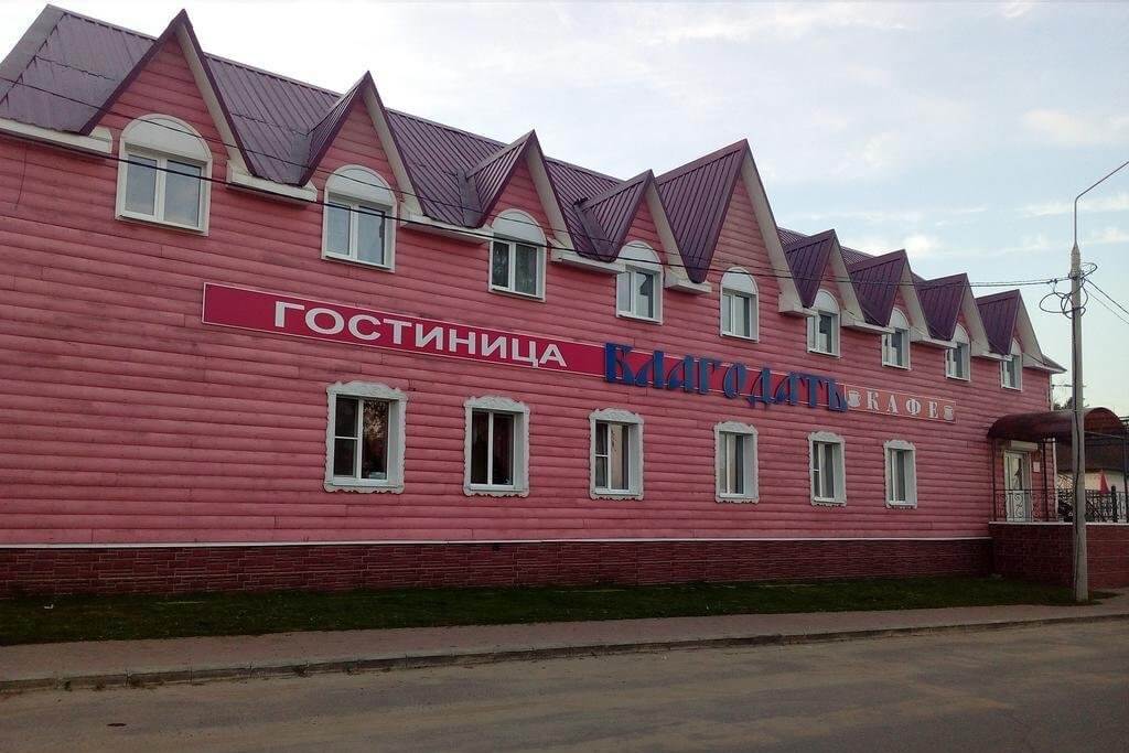 Фасад здания выкрашен в розово-красный цвет.