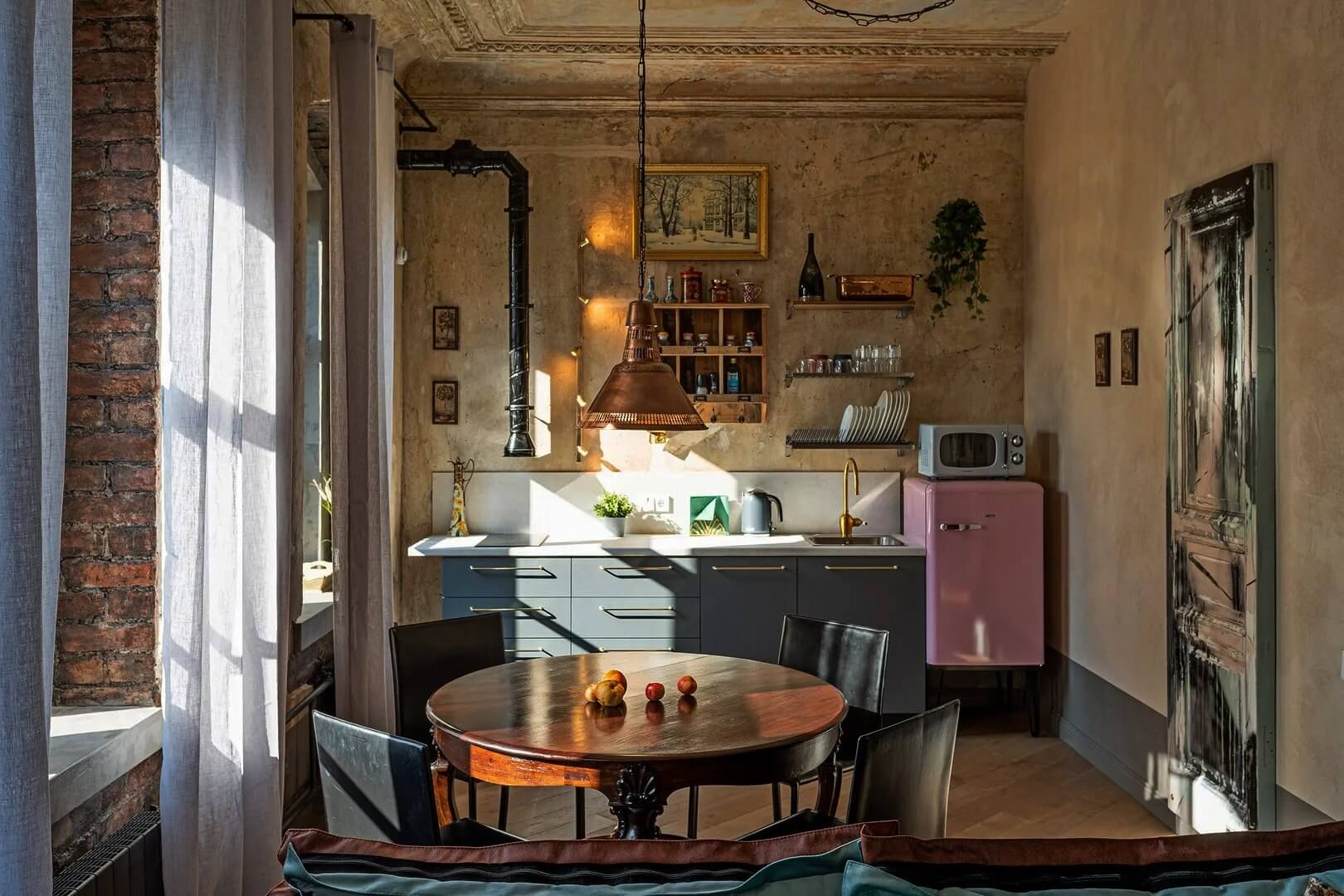 Кухонная зона, над столом красивая люстра с медным абажуром.