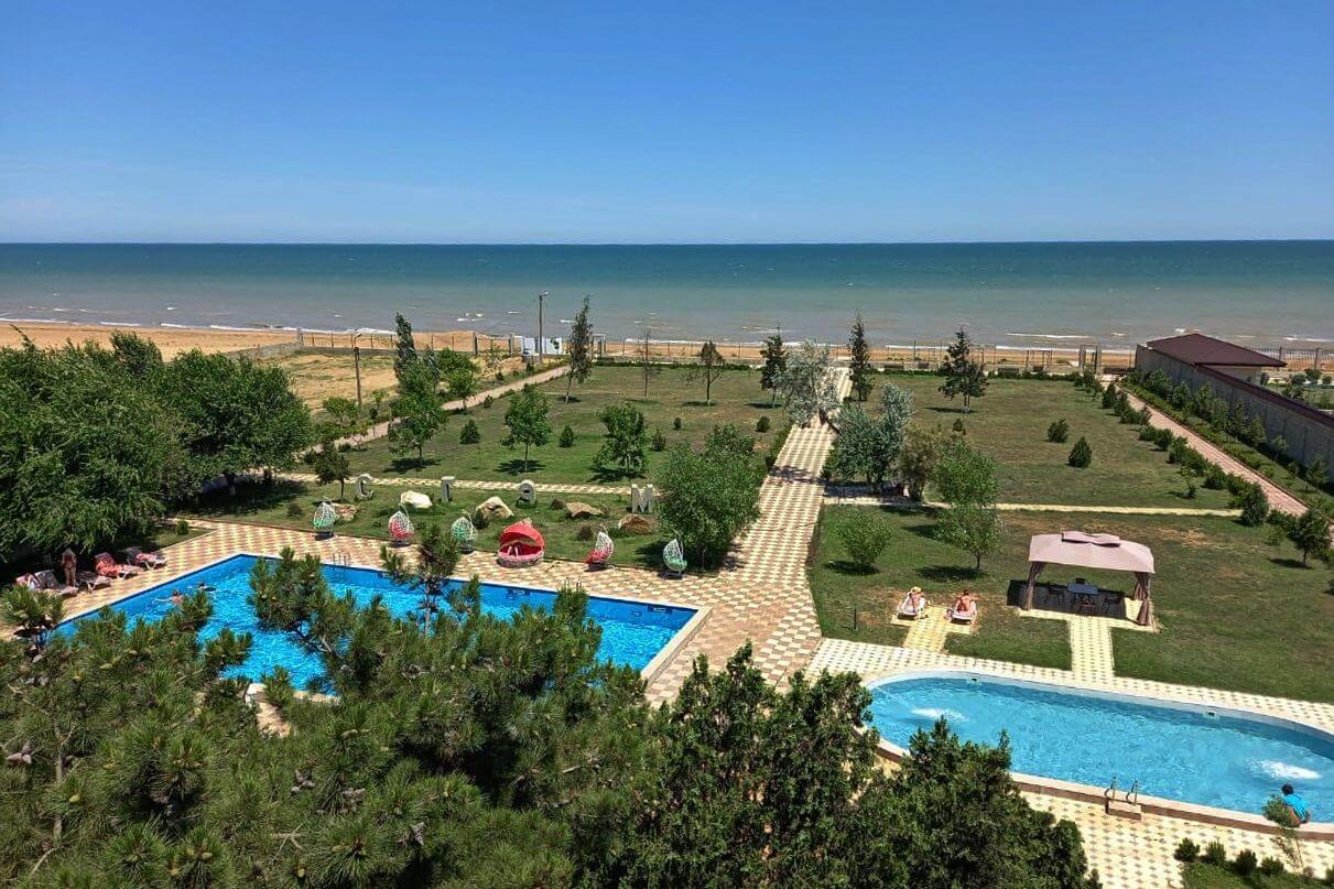 Вид на территорию отеля: два бассейна, лужайки для отдыха, пляж и море.