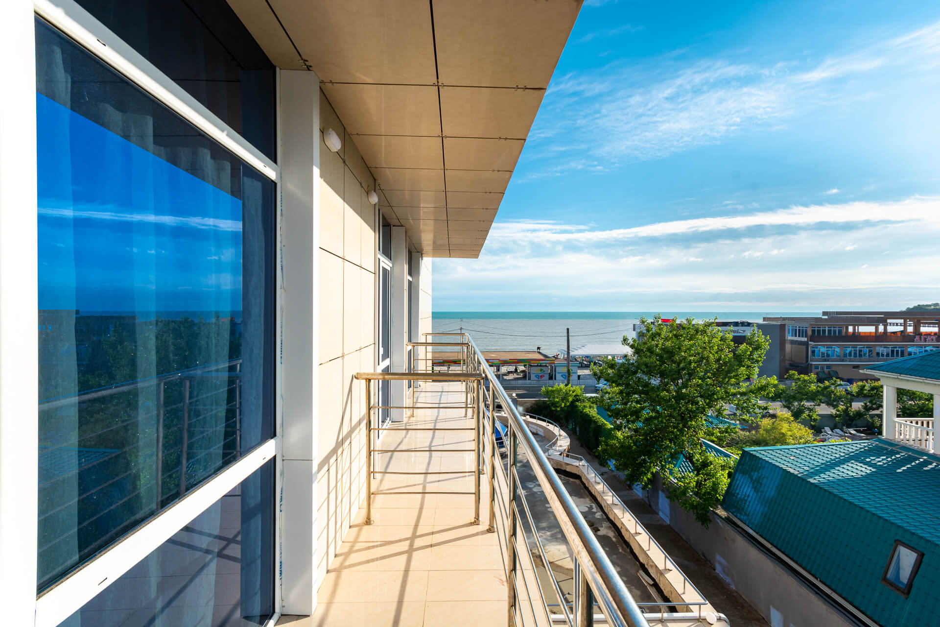 Вид с балконов - на крыши соседних домов и Черное море.