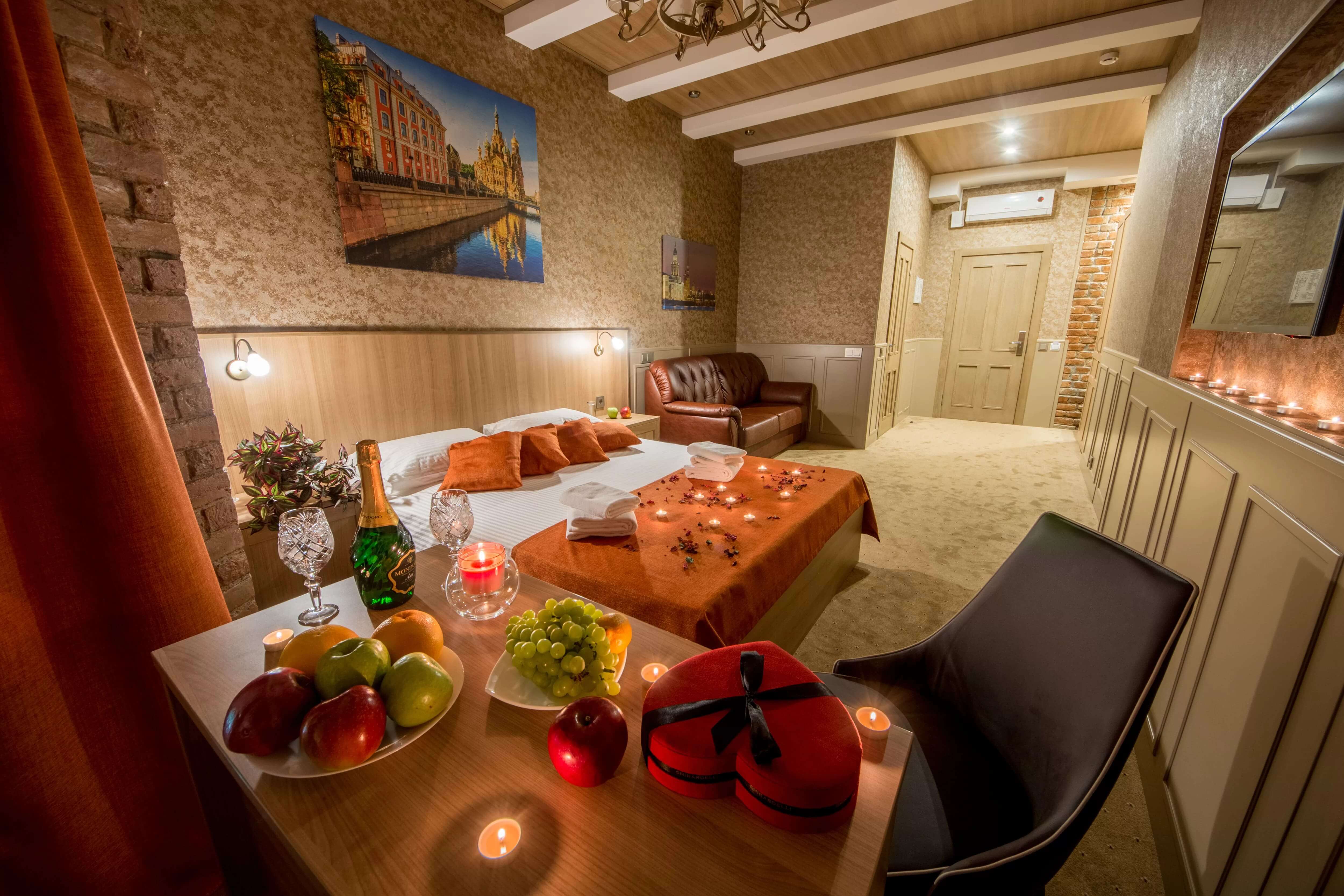 Гостиничный номер для романтического отдыха: свечи, шампанское, фрукты и сладости.