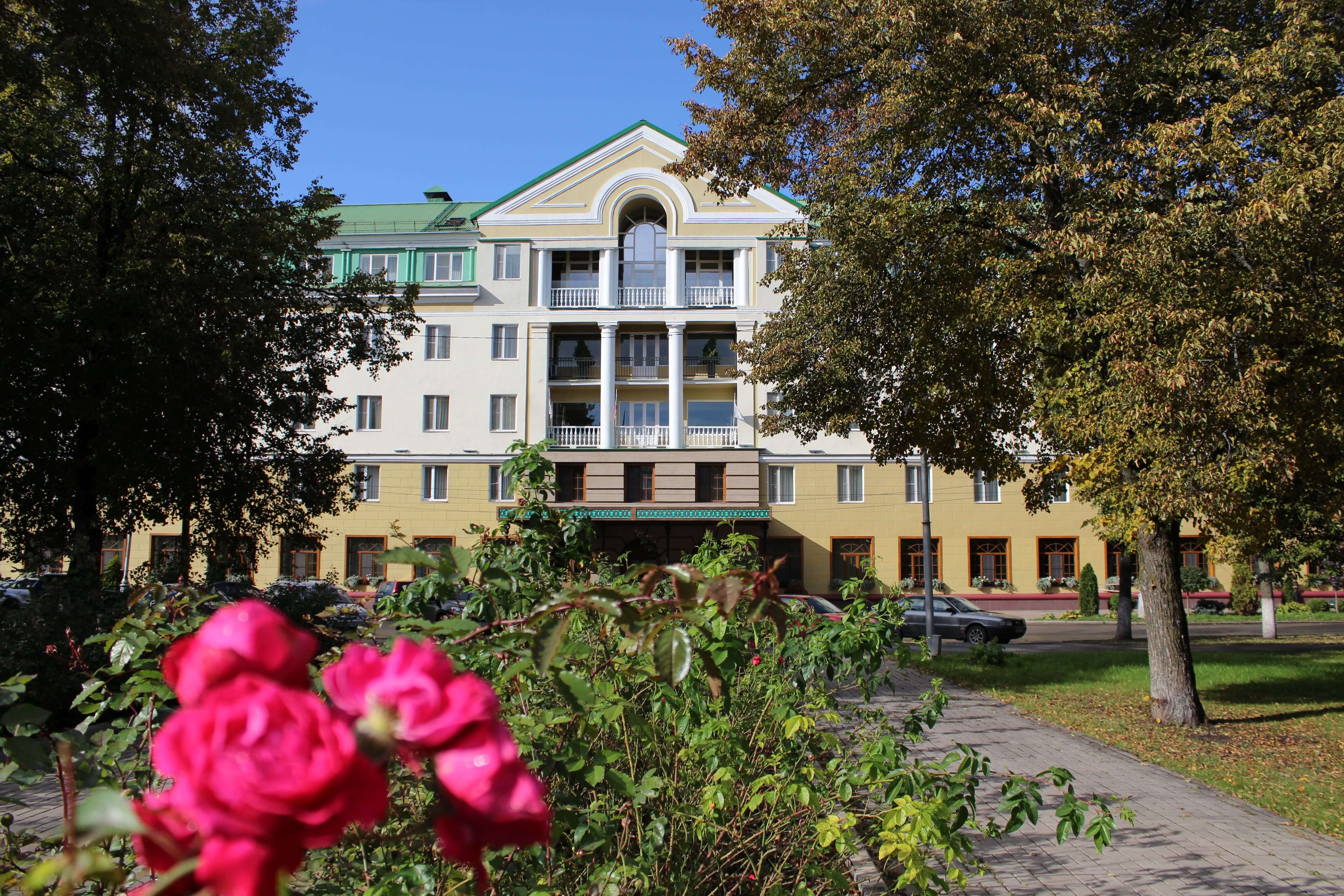 Центральный фасад и цветы на аллее перед отелем.