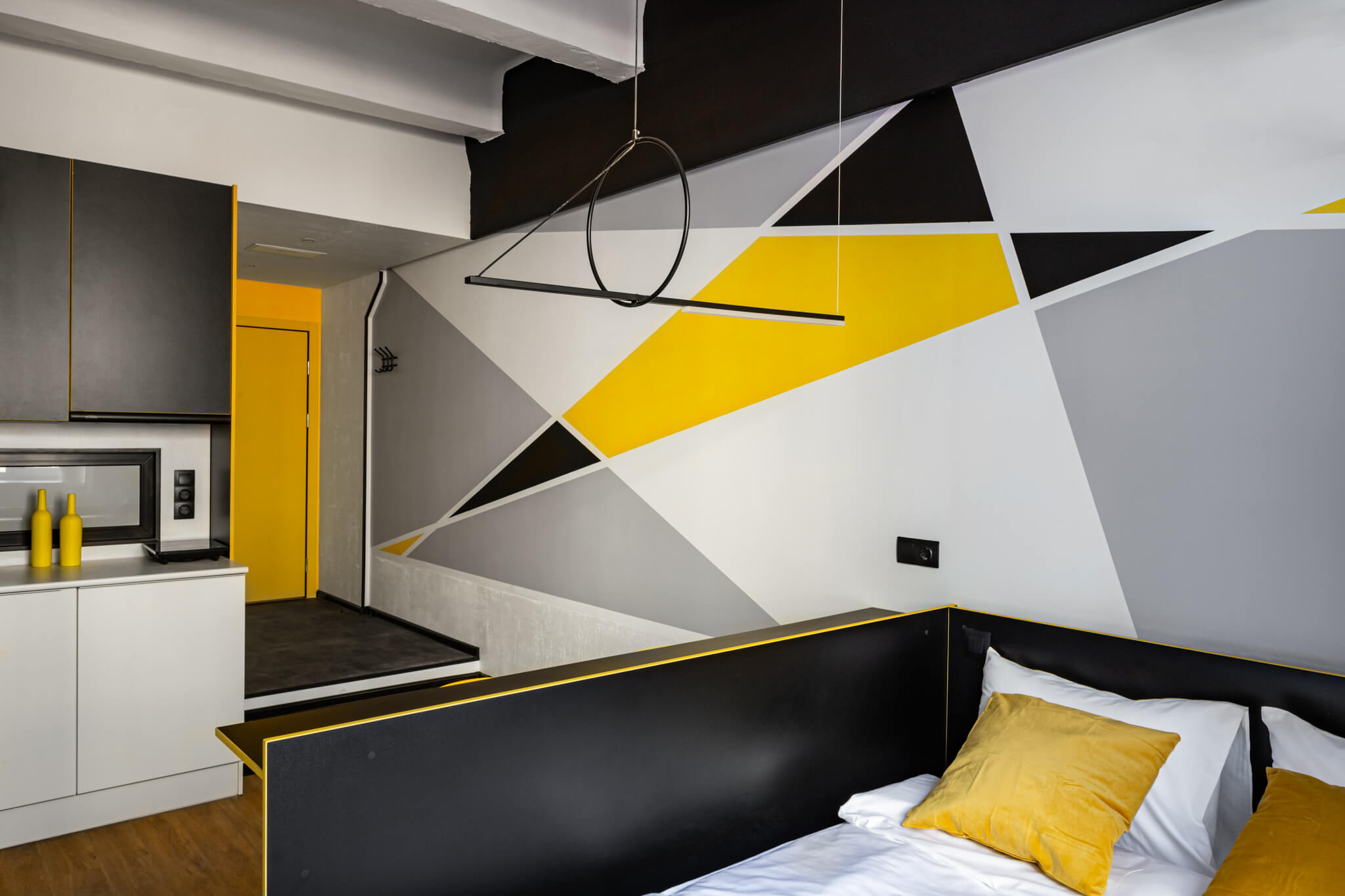 Стены в номере выкрашены в контрастные цвета: черный, желтый, белый и серый.
