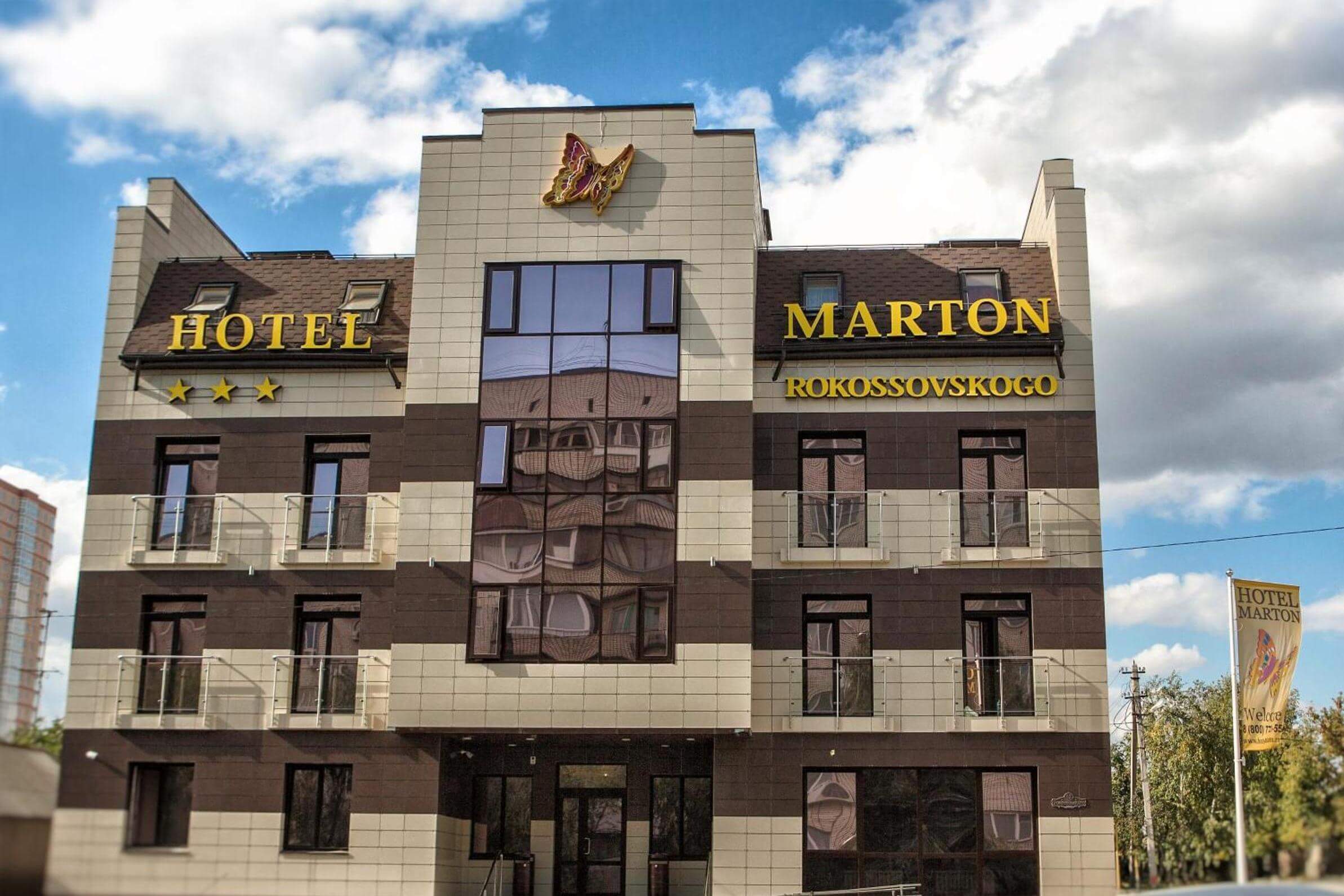 Мартон Рокоссовского. Здание отеля, фасад облицован декоративными панелями серого и коричневого цвета.
