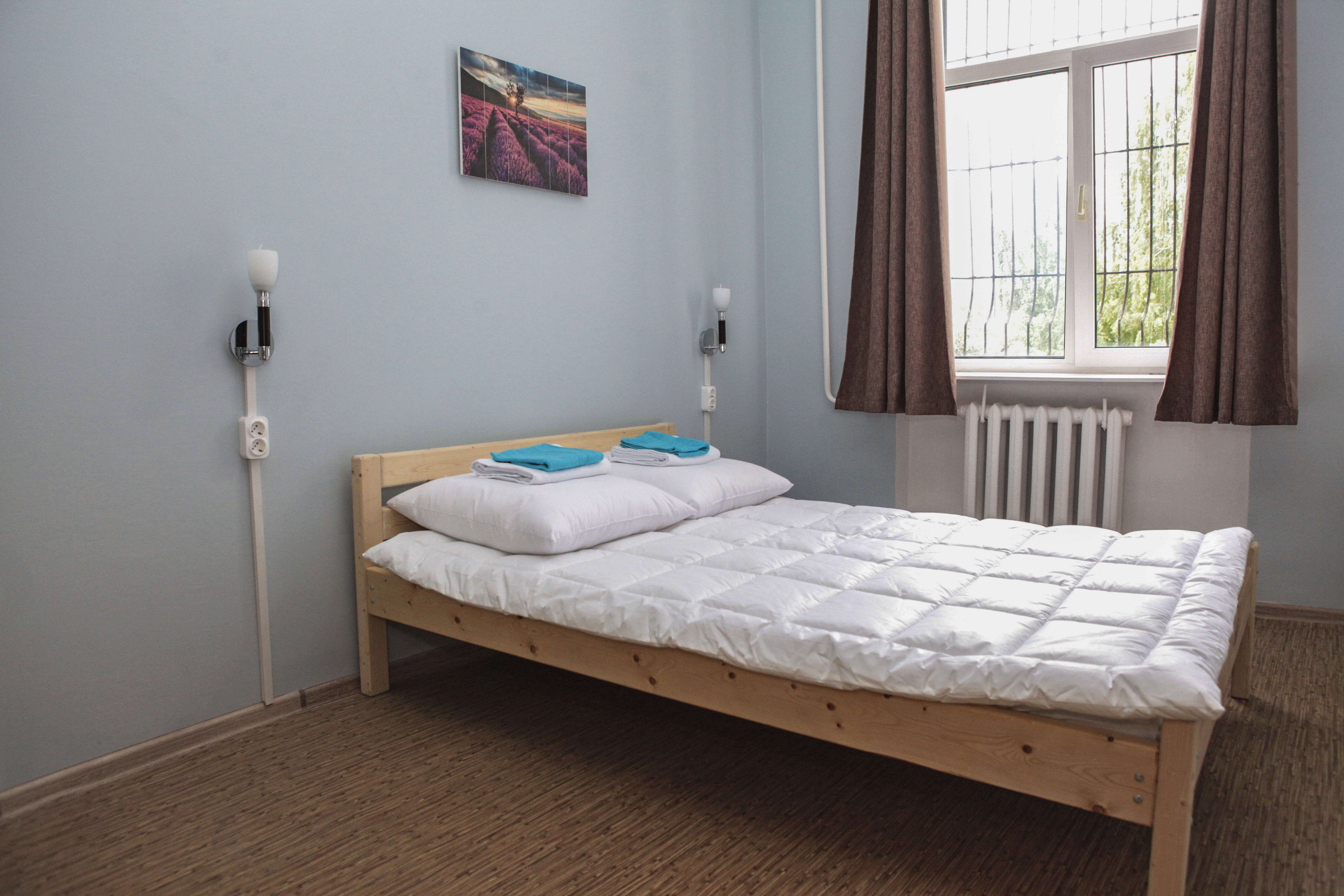Эконом отдых: деревянная кровать, окно с решеткой.