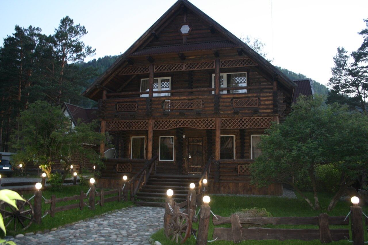 Красивый деревянный дом, вечерняя подсветка территории.