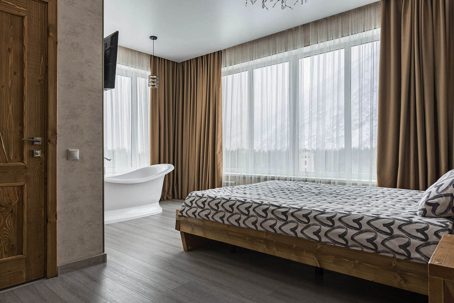 В номере: большая кровать и панорамные окна, открытая ванна у кровати.
