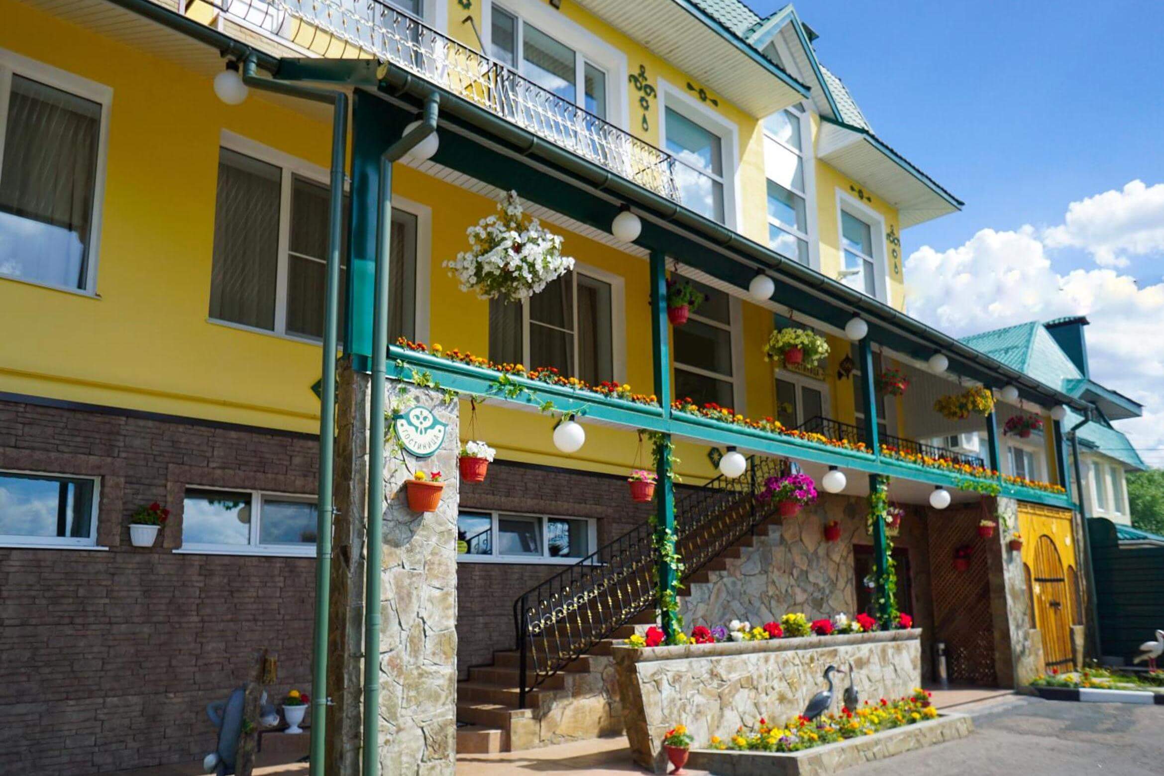 Фасад и входная группа украшена цветами в горшках.