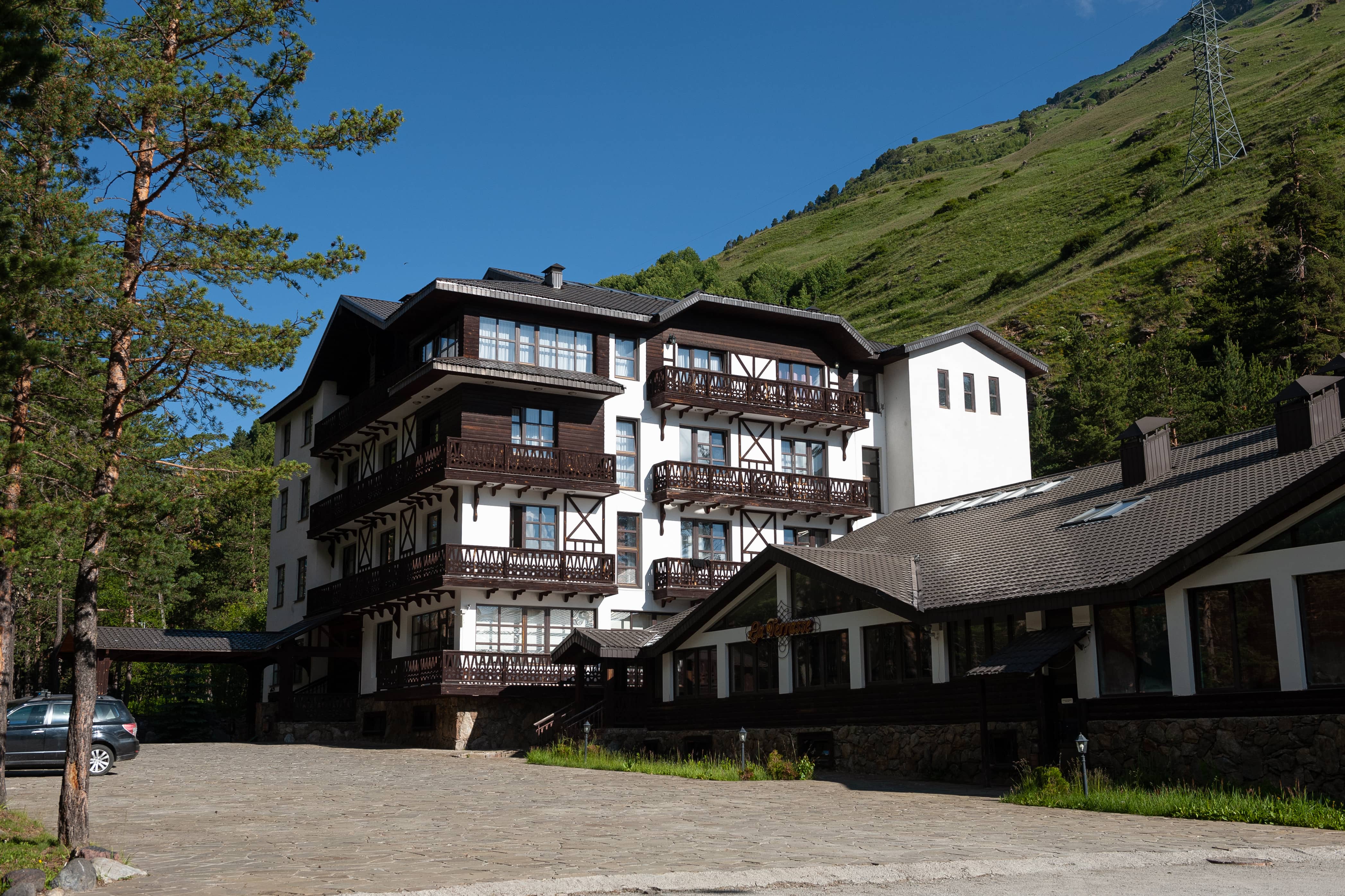 Красивая альпийская архитектура, сразу за отелем - высокий горный склон.