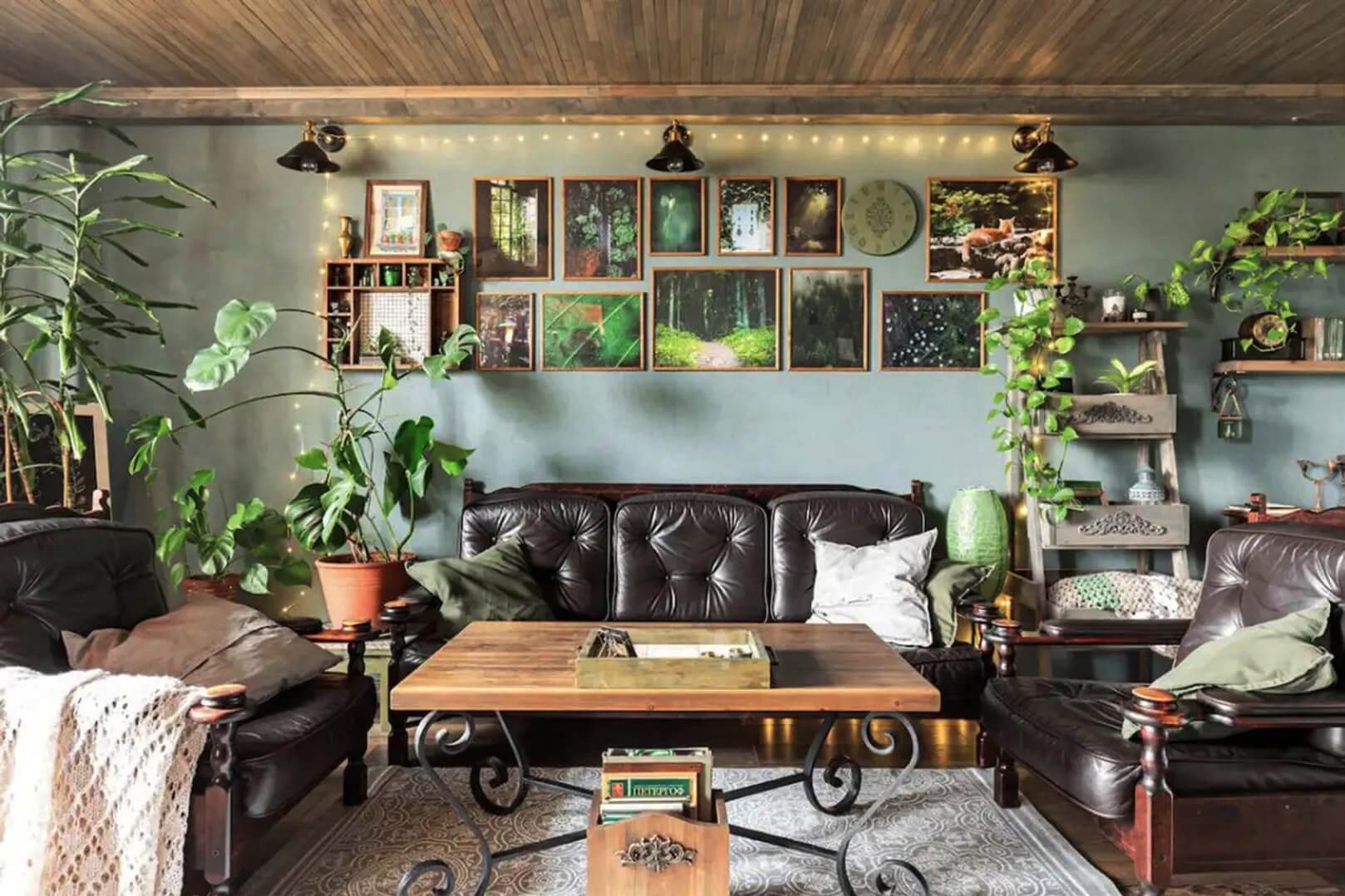 Зона отдыха: кожаные кресла, картины на стене и большое количество растений в горшках.