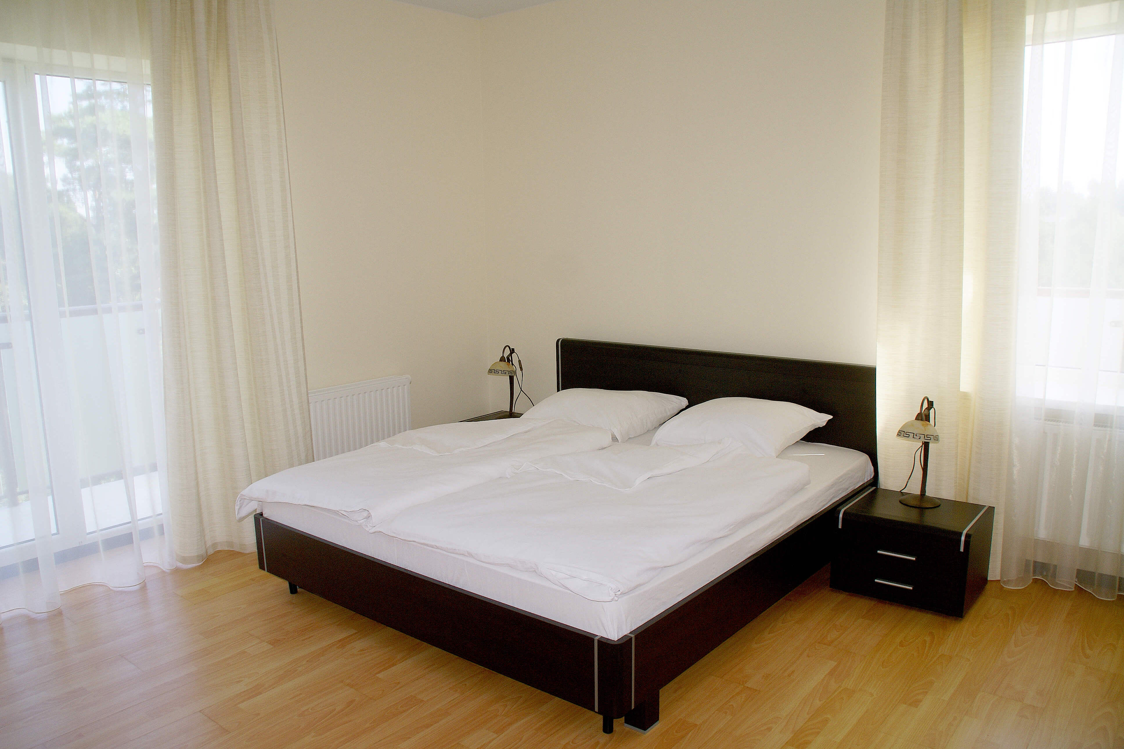 Большая кровать застелена белоснежным постельным бельем.