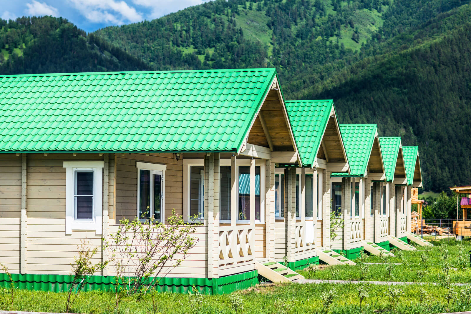 Стройный ряд домиков. Светло-зеленые крыши и светло-бежевые стены.