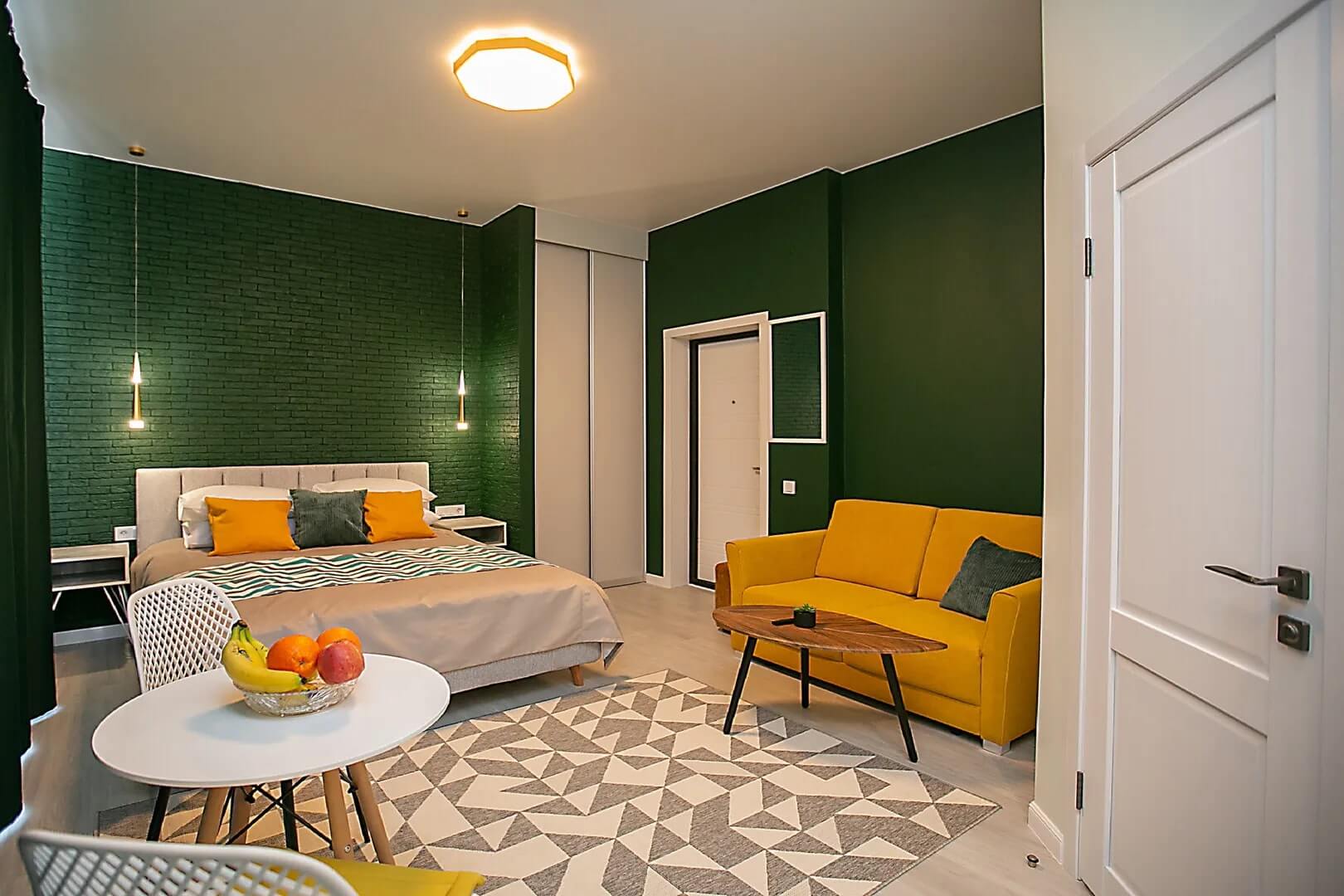 Стены в номере выкрашены в насыщенный зеленый цвет.