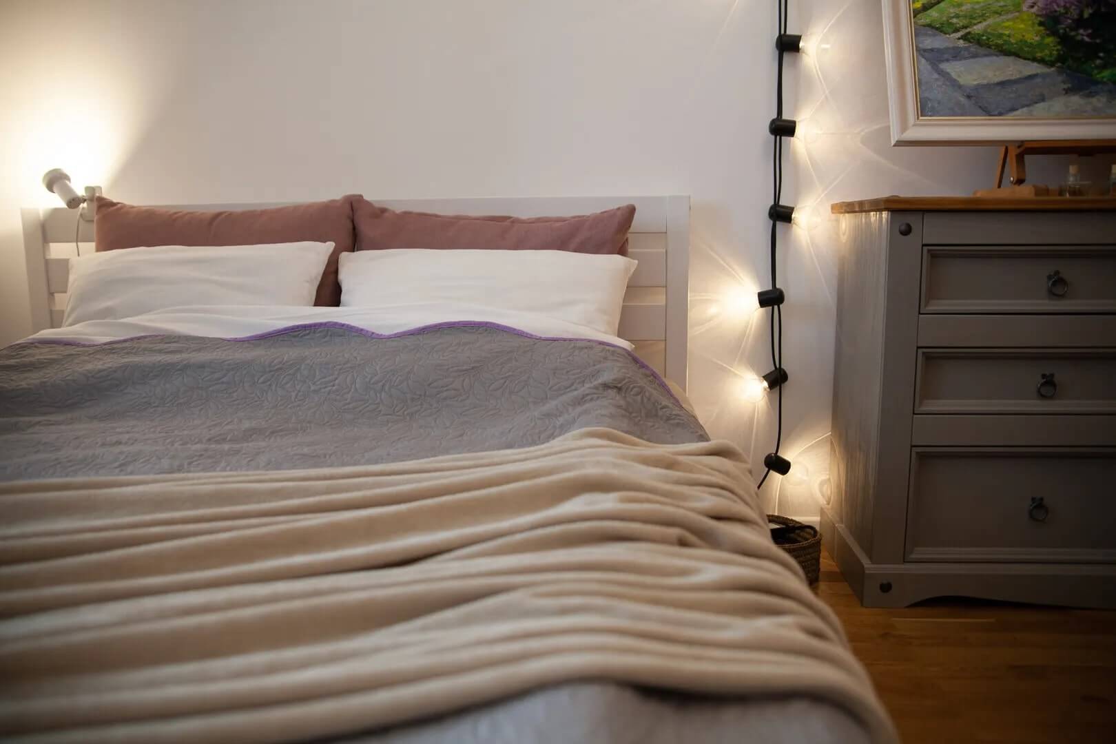 По стене у кровати плетется лиана-гирлянда.