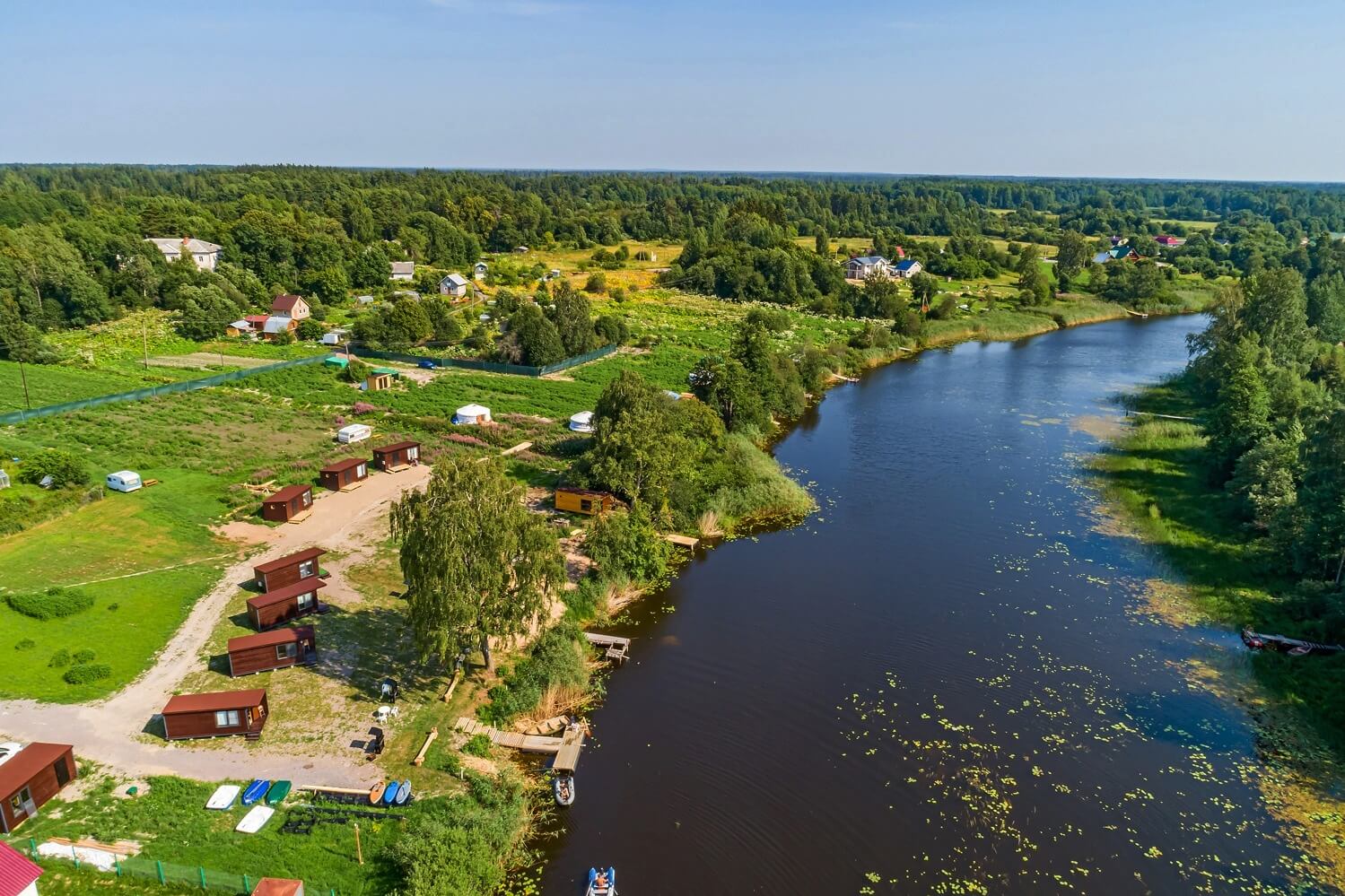 Панорамный вид: река и домики для отдыха.