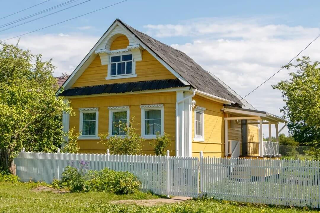 Стены дома выкрашены в яркий желтый цвет.