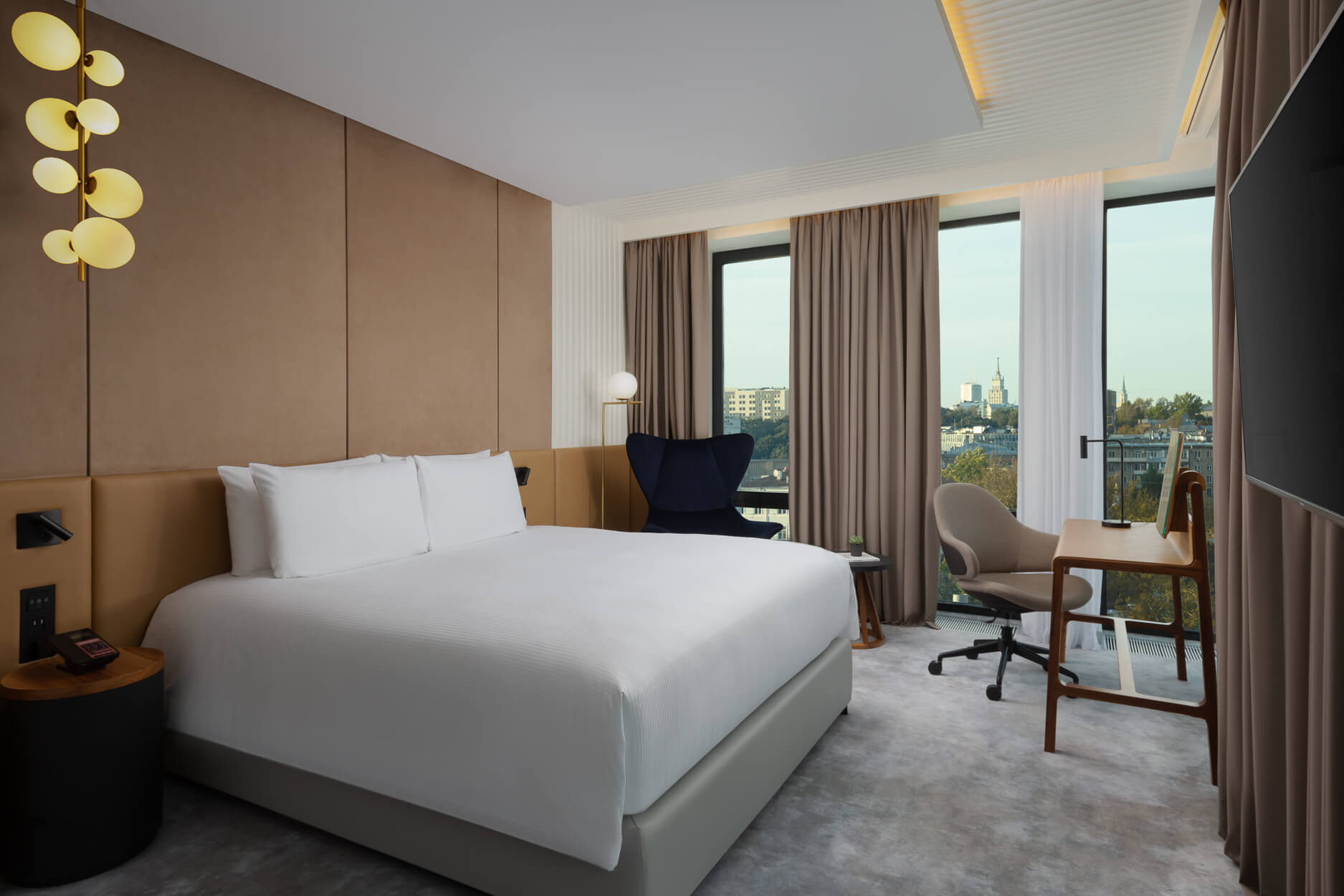В спальне: кровать застелена белоснежным бельем, большие панорамные окна.