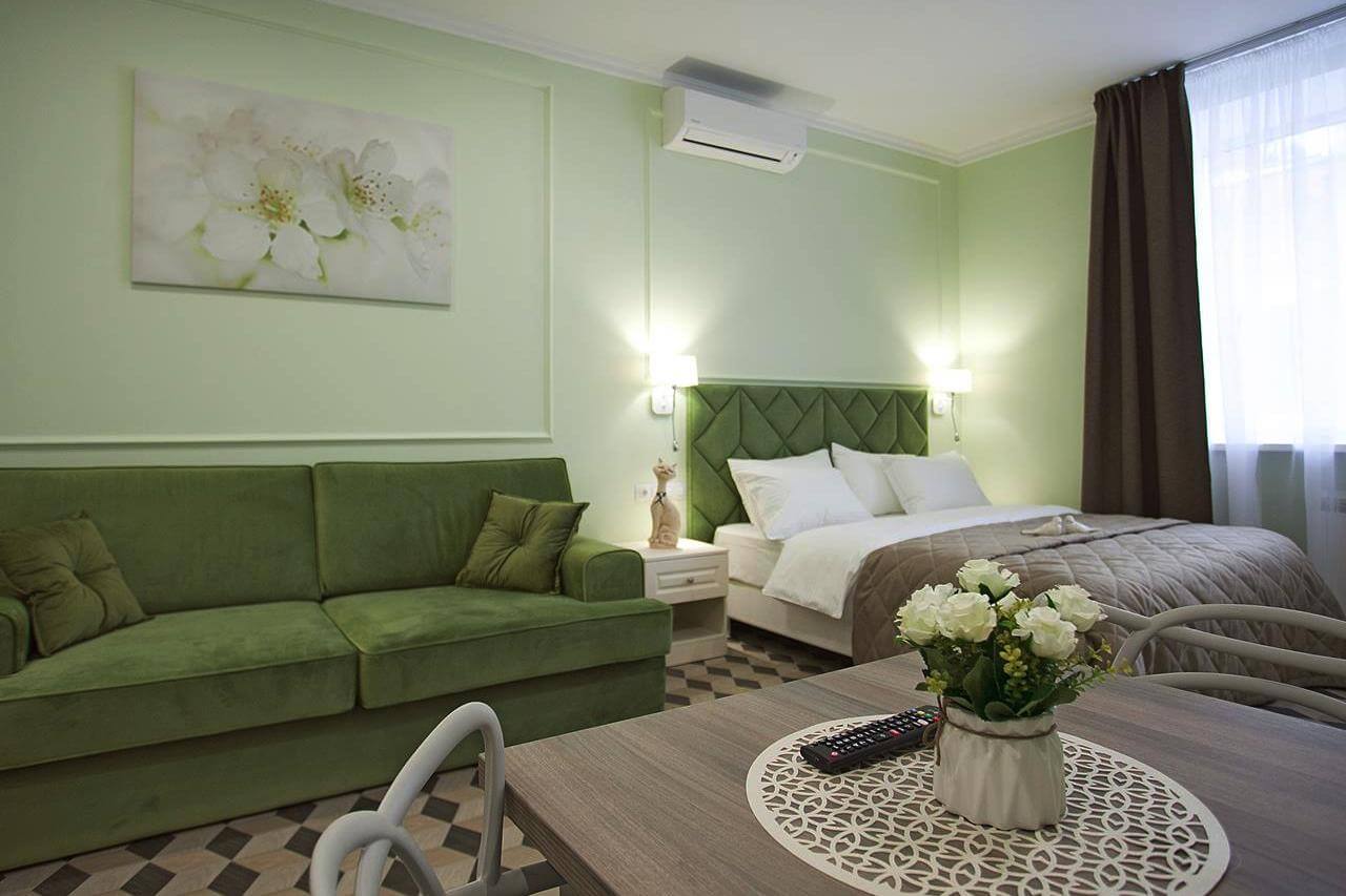 Стены, обивка дивана и изголовья кровати - зеленых оттенков.