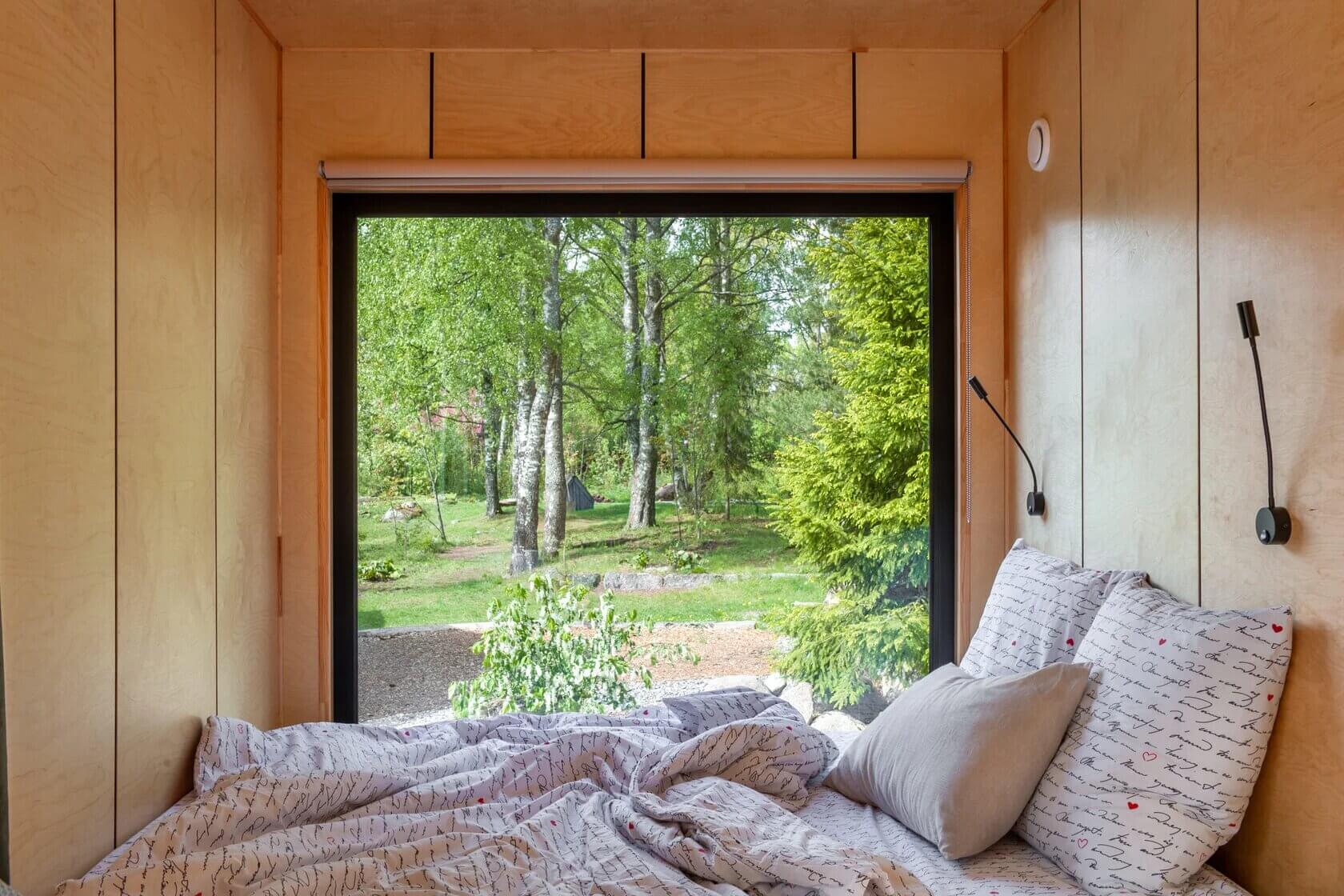 Спальное место оборудовано рядом с большим панорамным окном.
