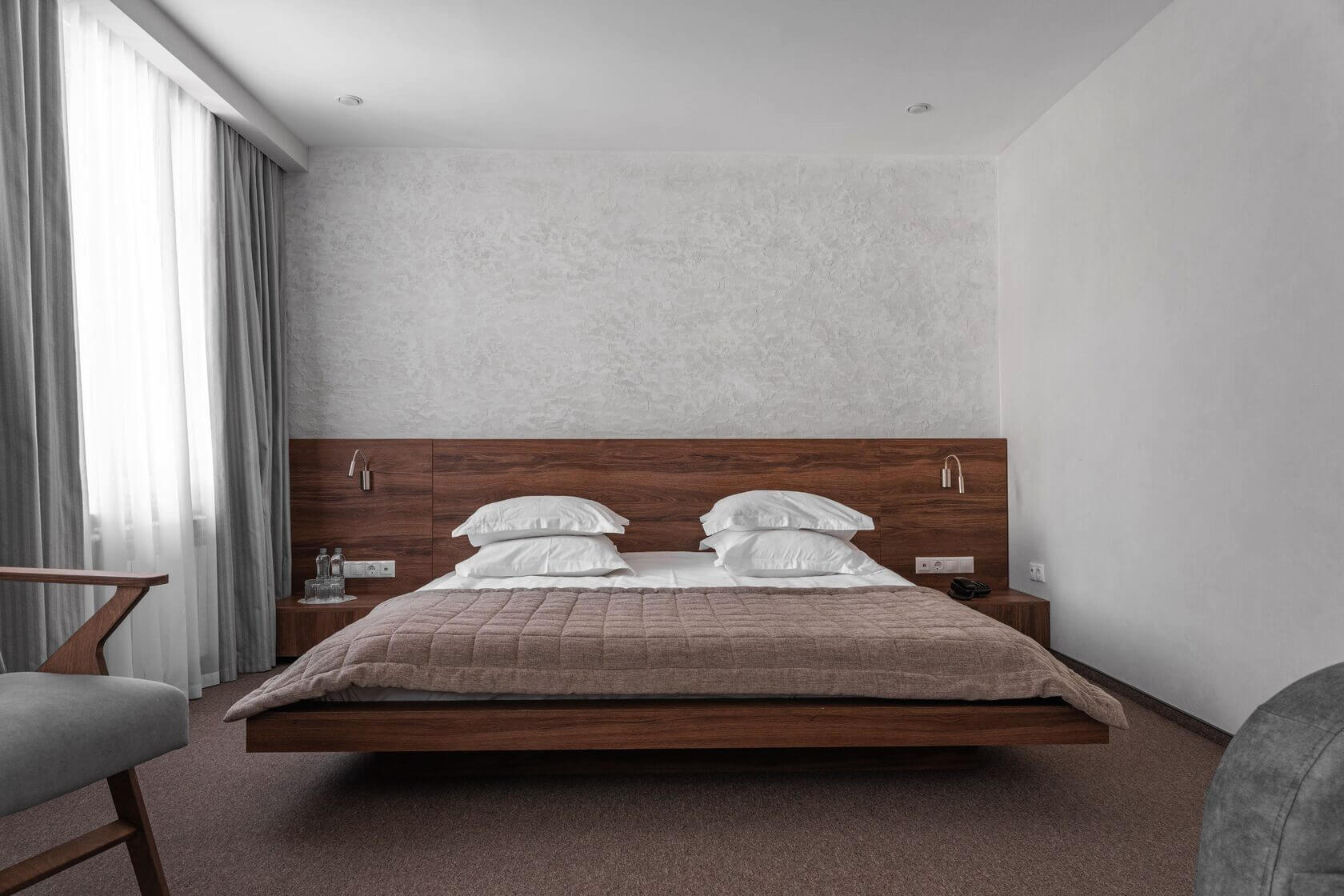Кровать в номере - низкопольная, с деревянным основанием и изголовьем.