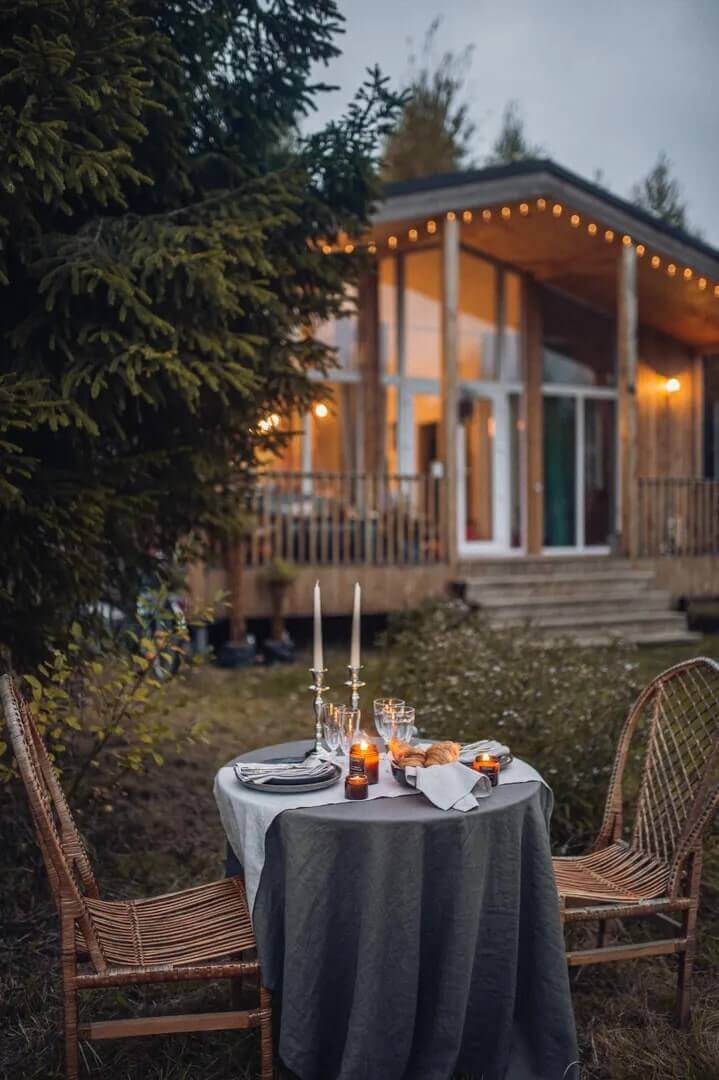 Перед домом установлен столик с красивой сервировкой для романтических ужинов.