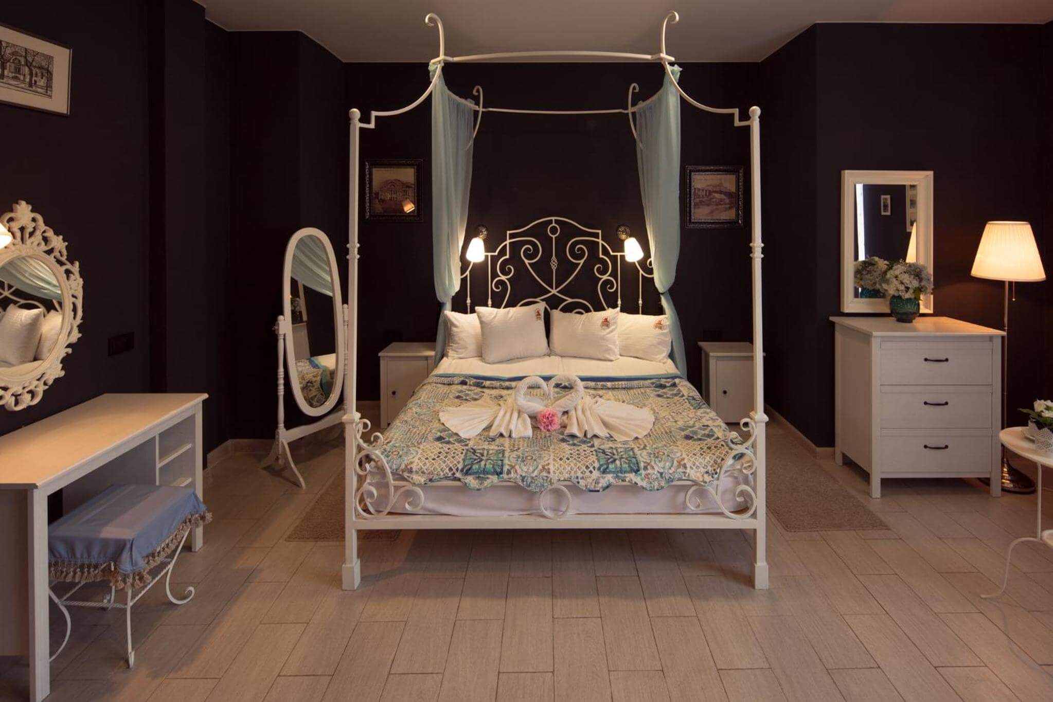В спальне: кровать с металлическим основанием и балдахином, зеркало и макияжный столик.