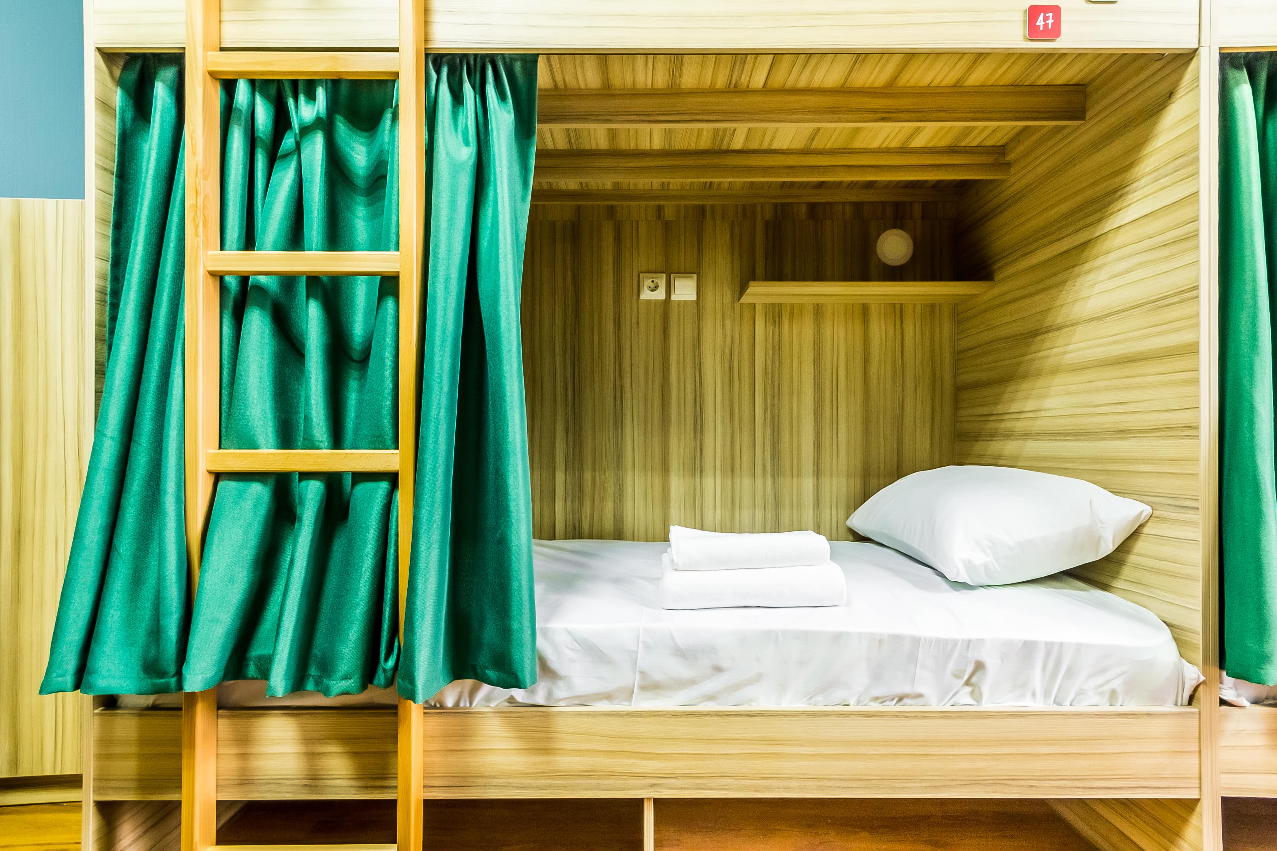 Кровать - деревянная, шторки - перламутровые зеленые.