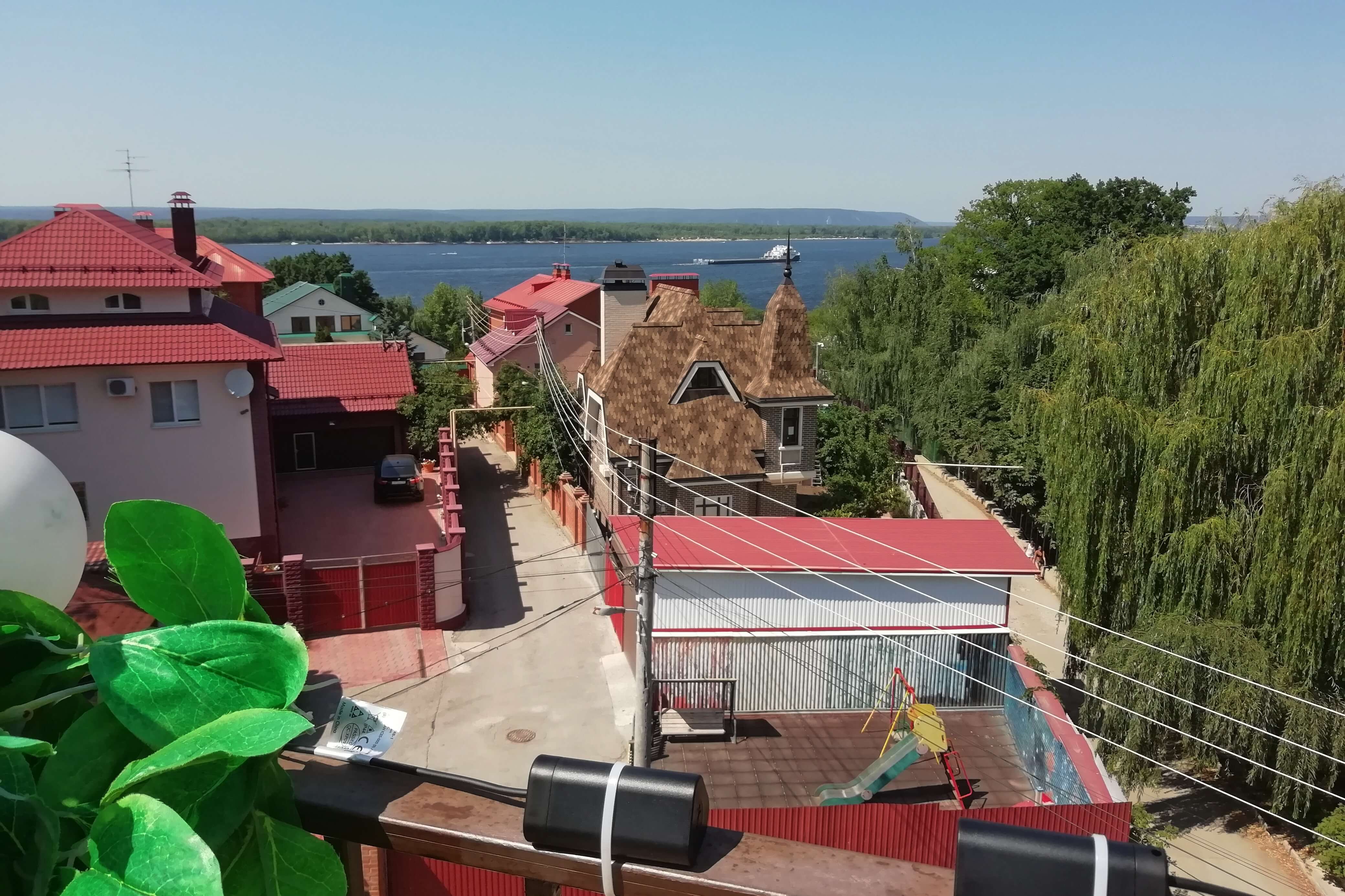 С террасы хорошо видна Волга с проплывающими катерами и баржами.