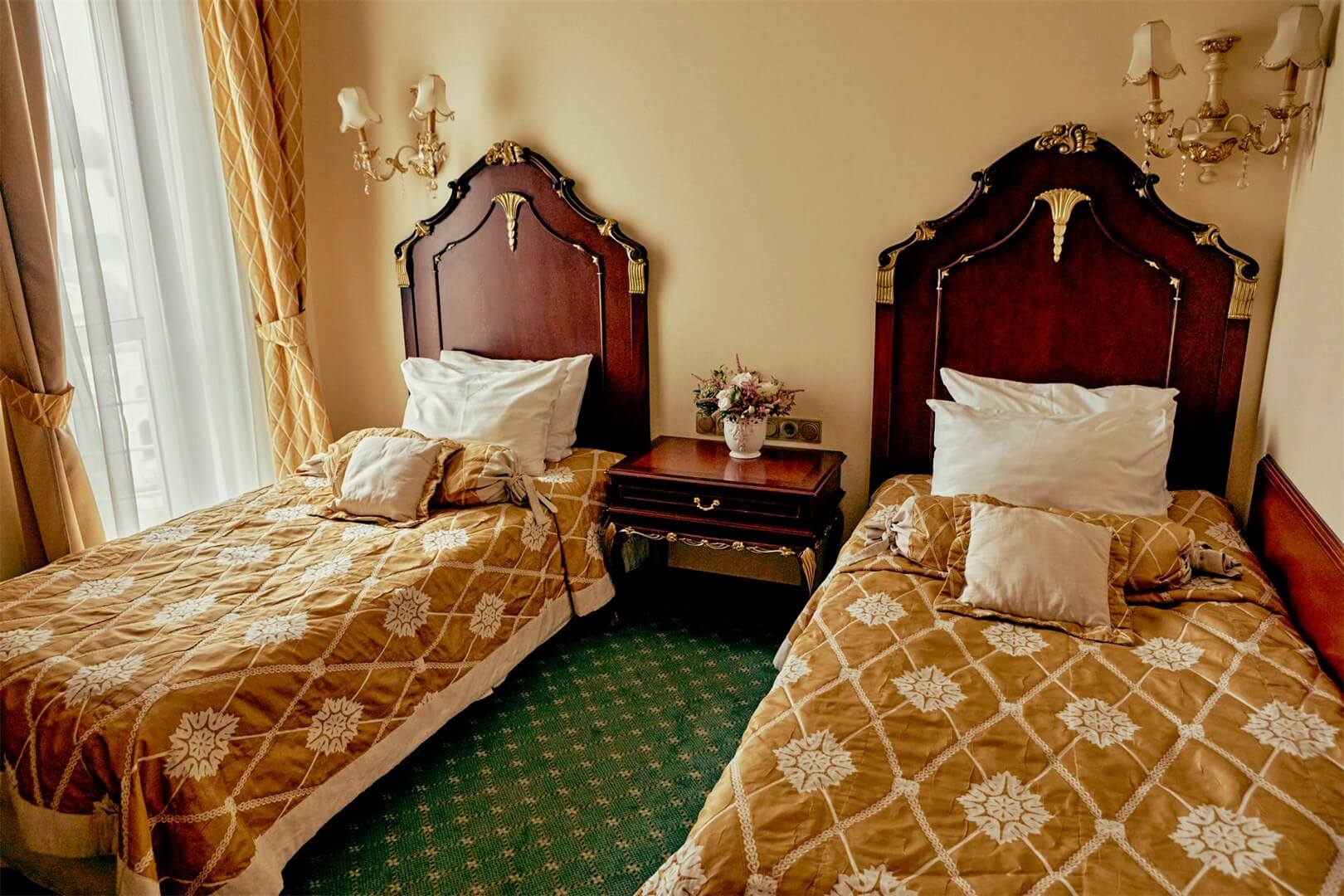 Две кровати с красивыми деревянными изголовьями.