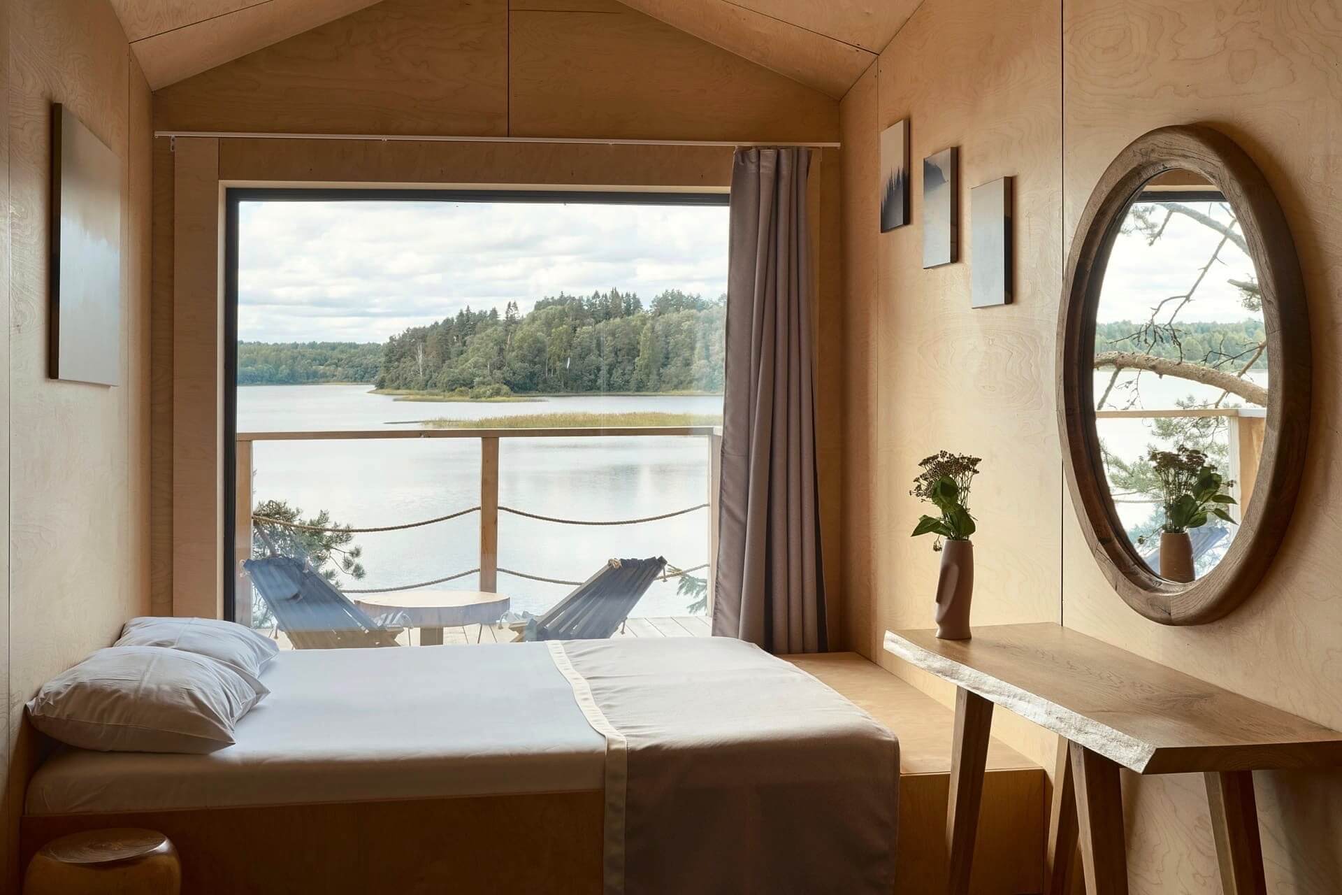 Спальное место обустроено рядом с большим панорамным окном.