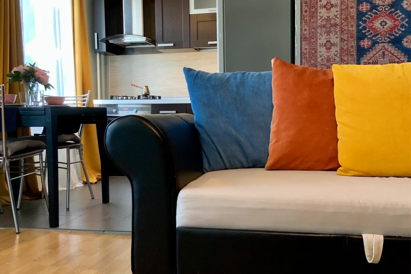 Центральный диван декорирован цветными подушками: синей, красной и желтой.