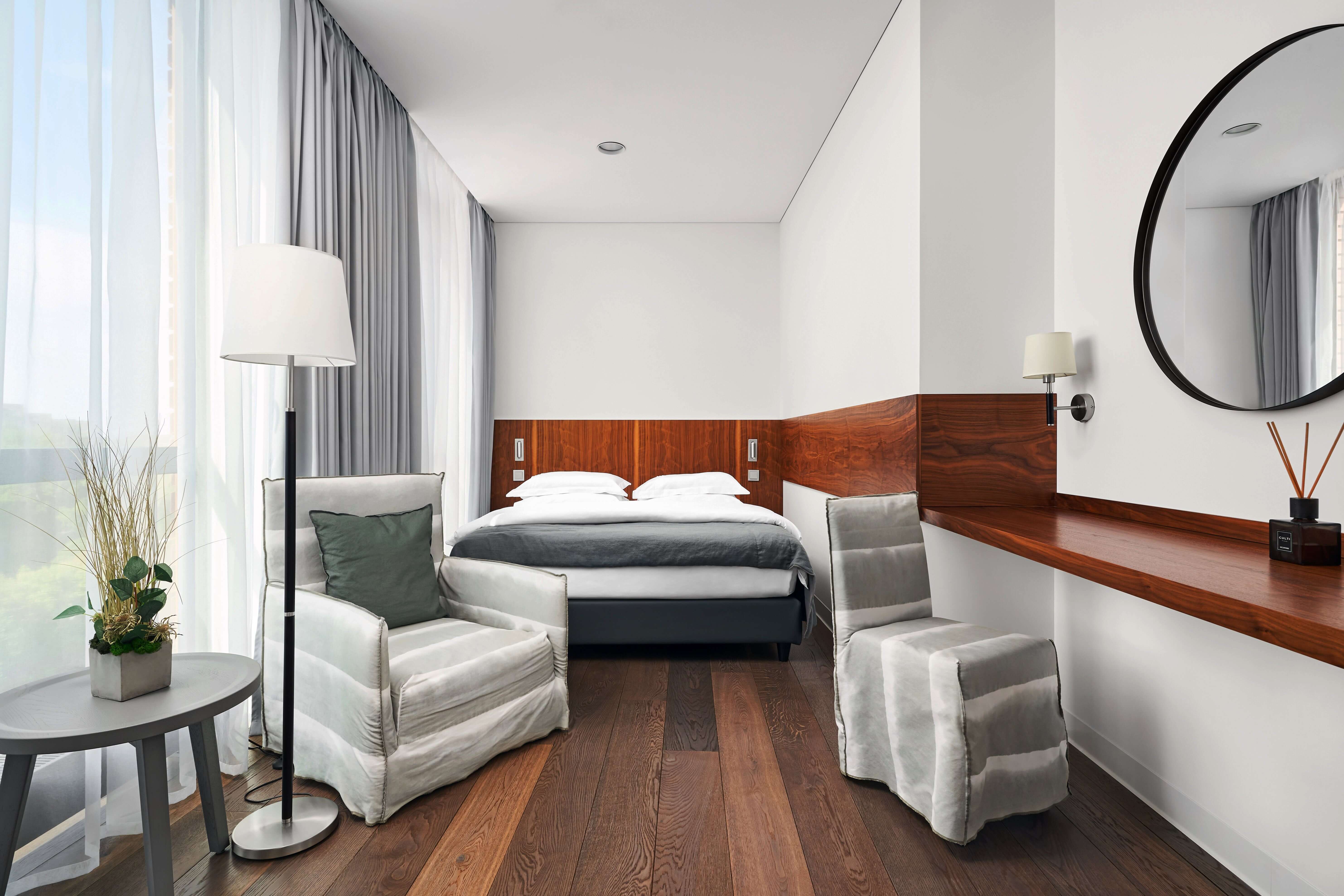 Crystal House Suite Hotel & Spa. Гостиничный номер: кровать с креслами, большое зеркало, светлые стены.