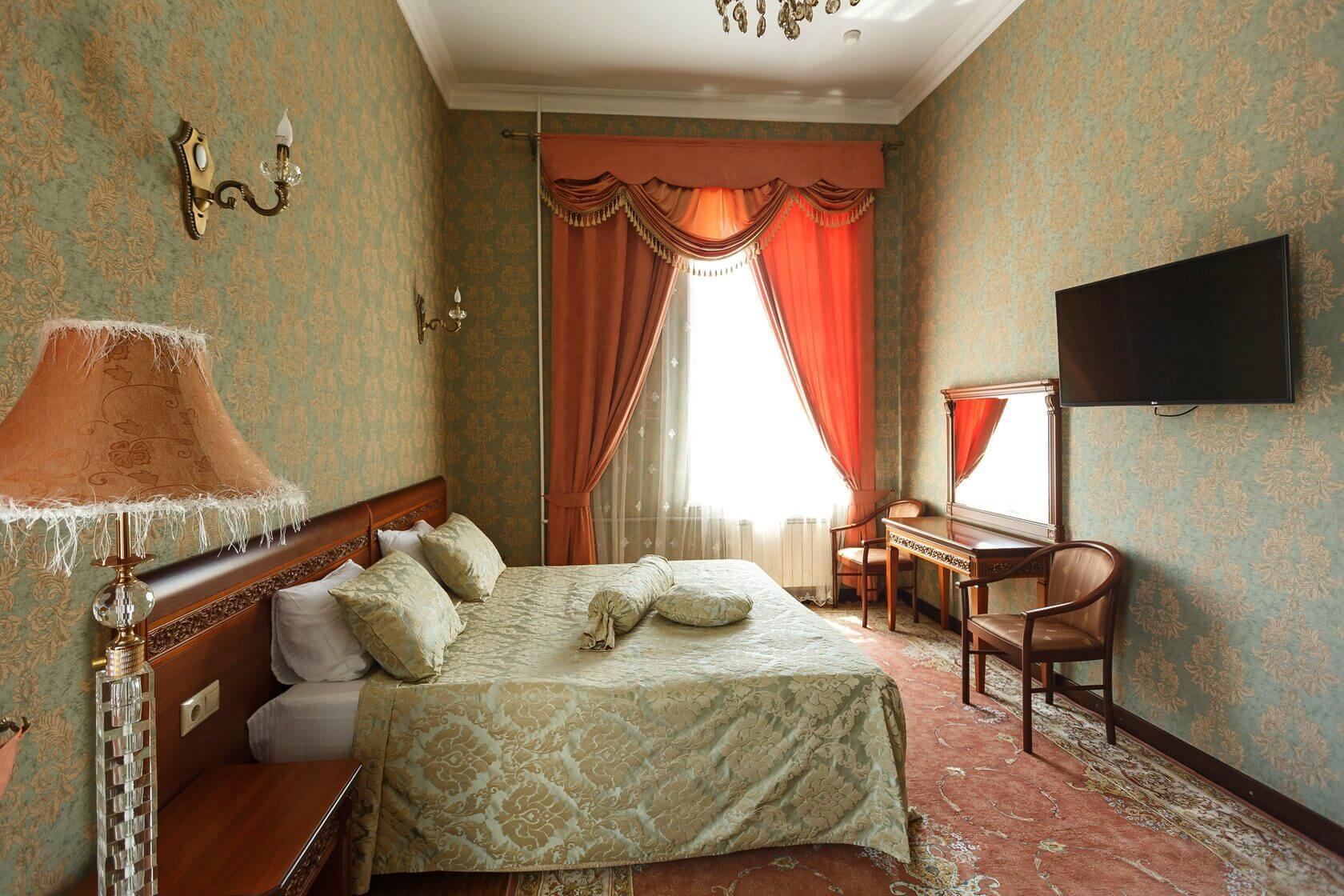 В номере: на окне - красивые портьеры, на полу - ковер, на тумбочке у кровати - лампа с красивым абажуром.