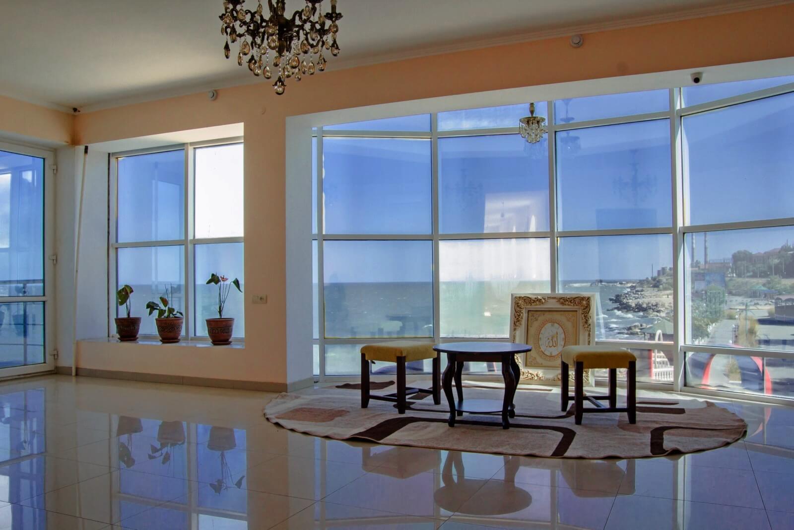Холл гостиницы - панорамное остекление с видом на берег моря.