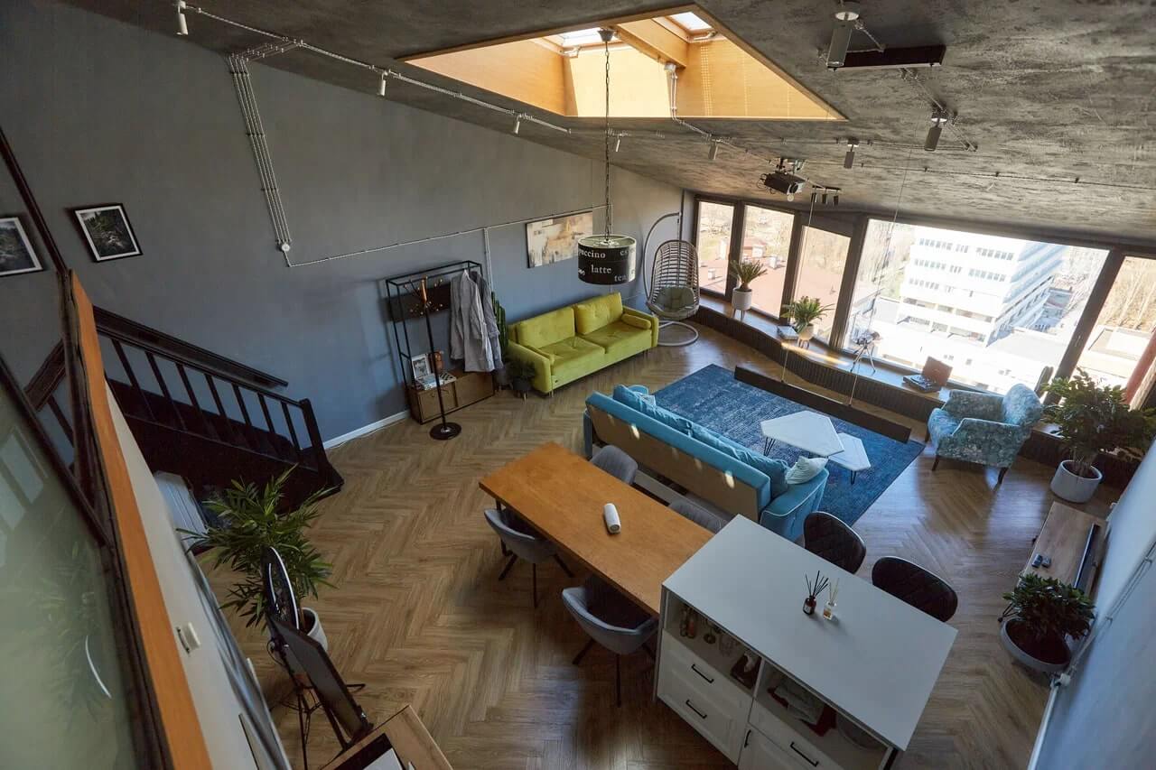 Вид со второго яруса: зона кухни и спальни, диван и кресло-кокан у панорамного окна.