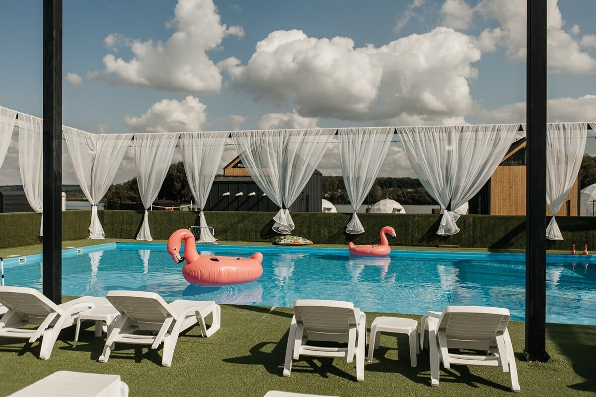 В бассейне плавают надувные фламинго.